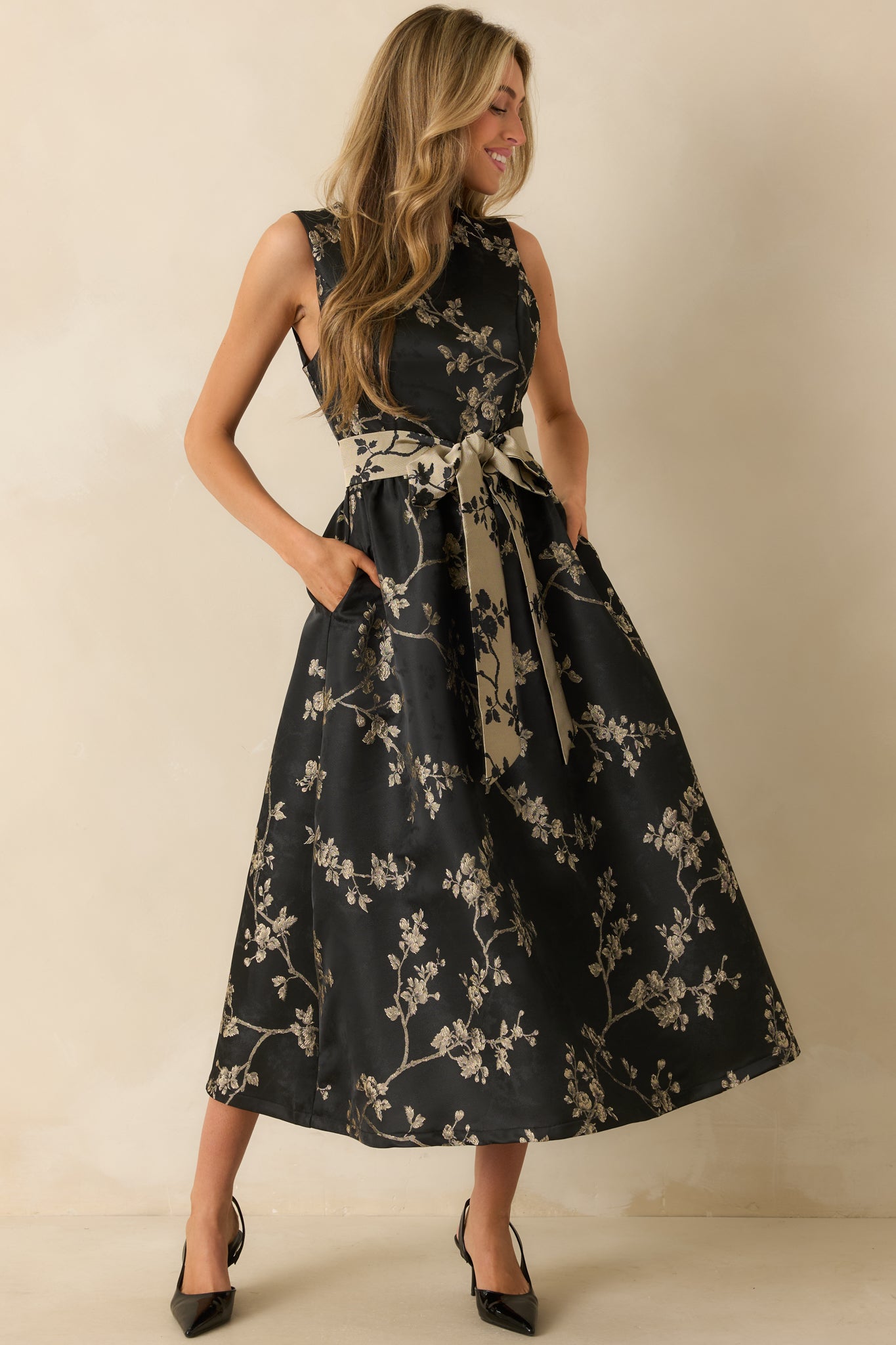 Full front view showing the black floral jacquard midi dress with sleeveless bodice and round neckline.