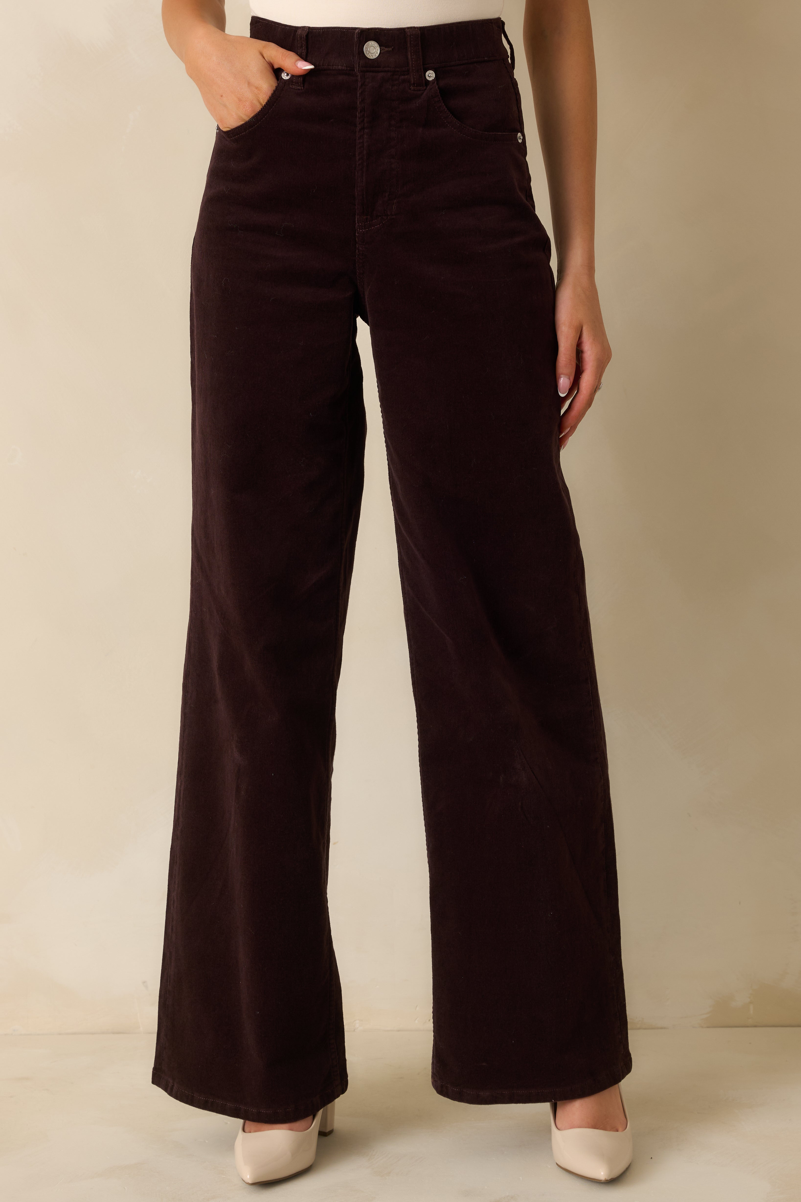 Dark brown corduroy jeans with a high-rise waist and wide-leg silhouette, showing full length front view.