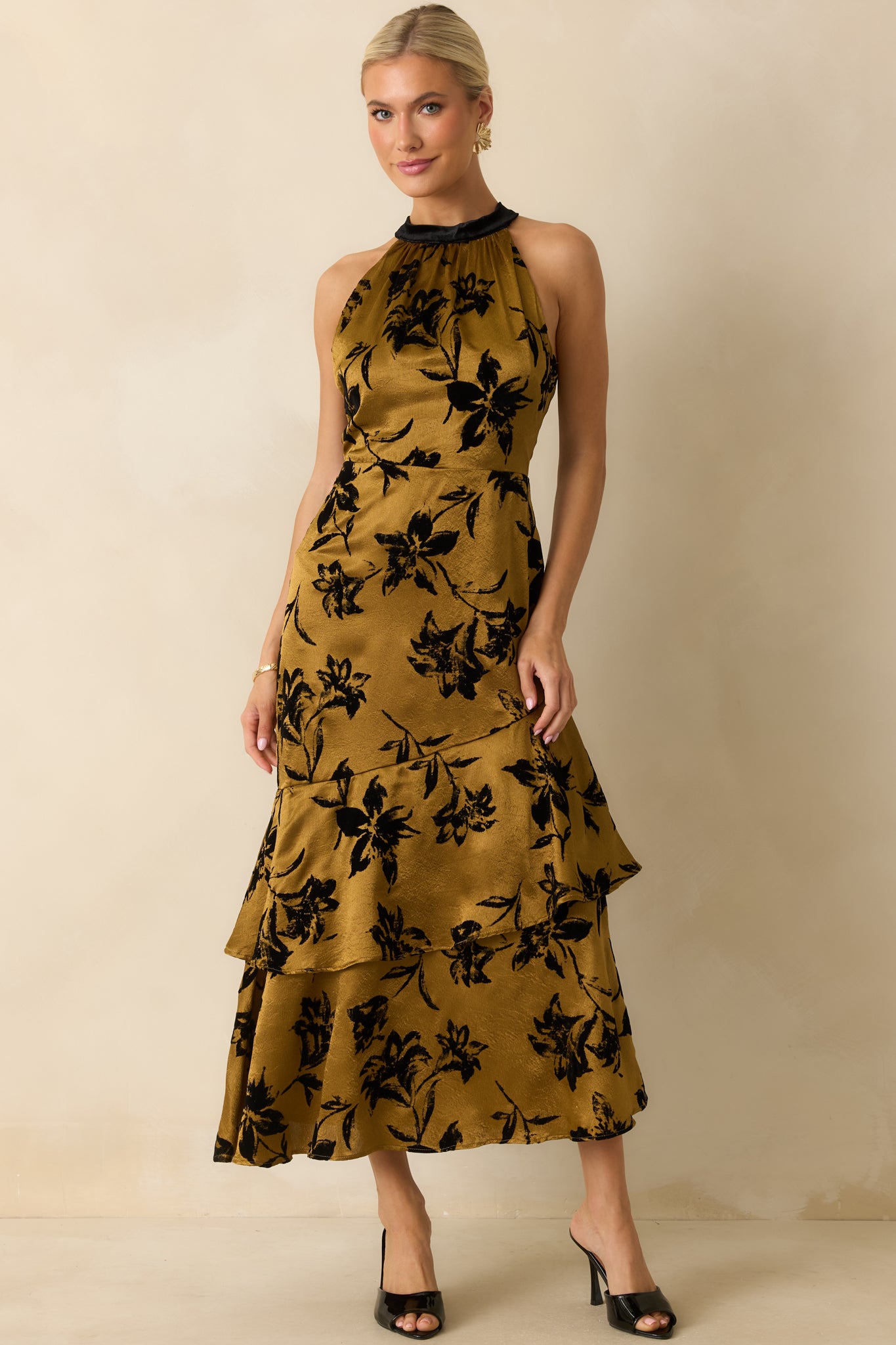 Full front view of the dark gold satin midi dress emphasizing the black velvet bow tie at the halter neckline.