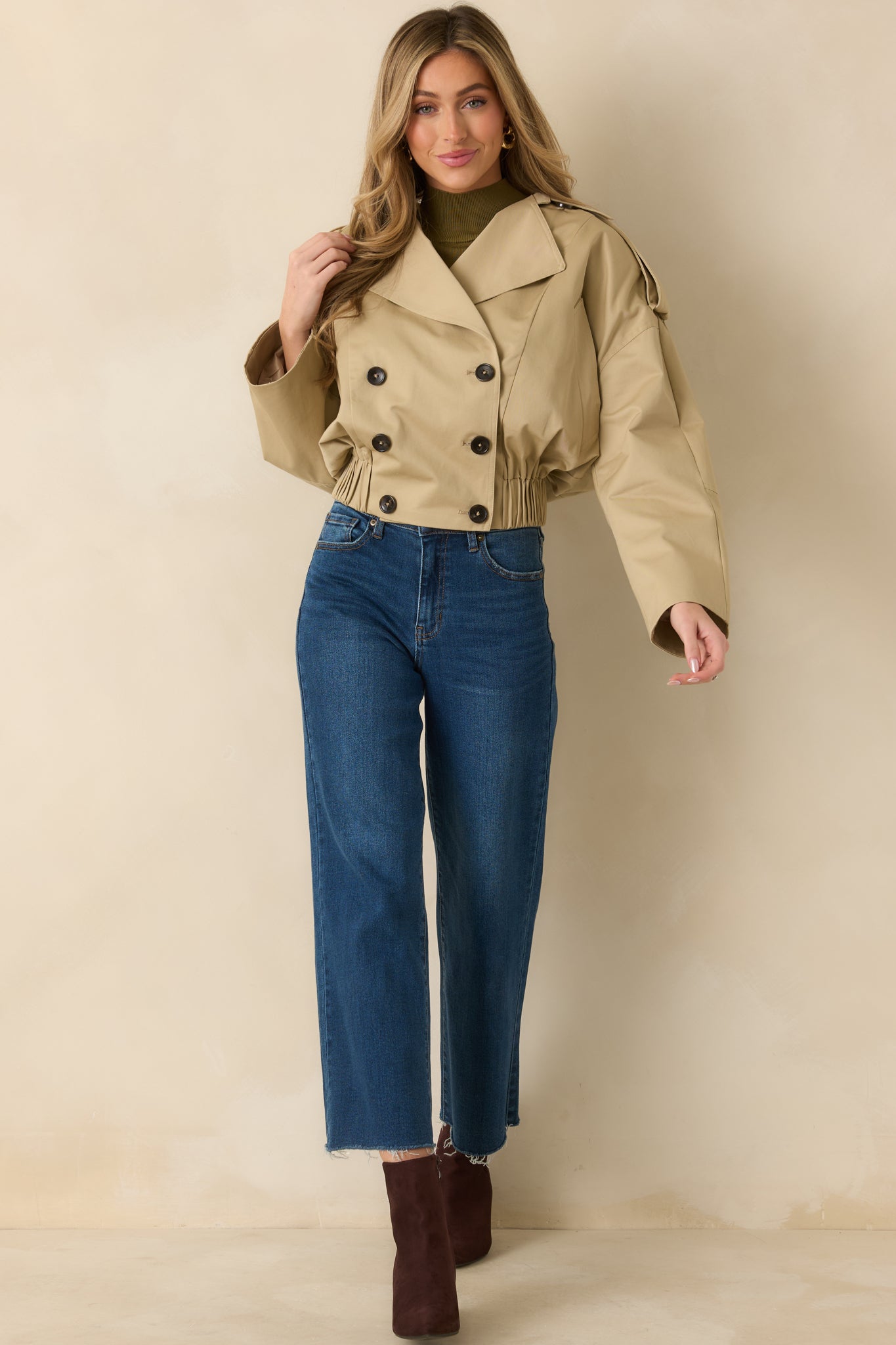 Full-length angle capturing detachable belt tabs, buttoned cuffs, and clean front shaping.