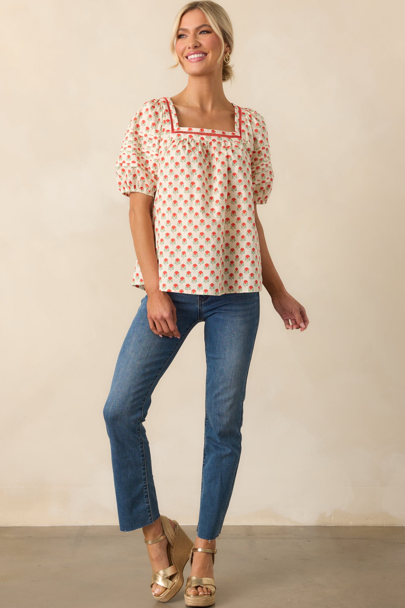A full-length image showcasing the red floral cotton top with elastic-cuffed puff sleeves and a structured square neckline.