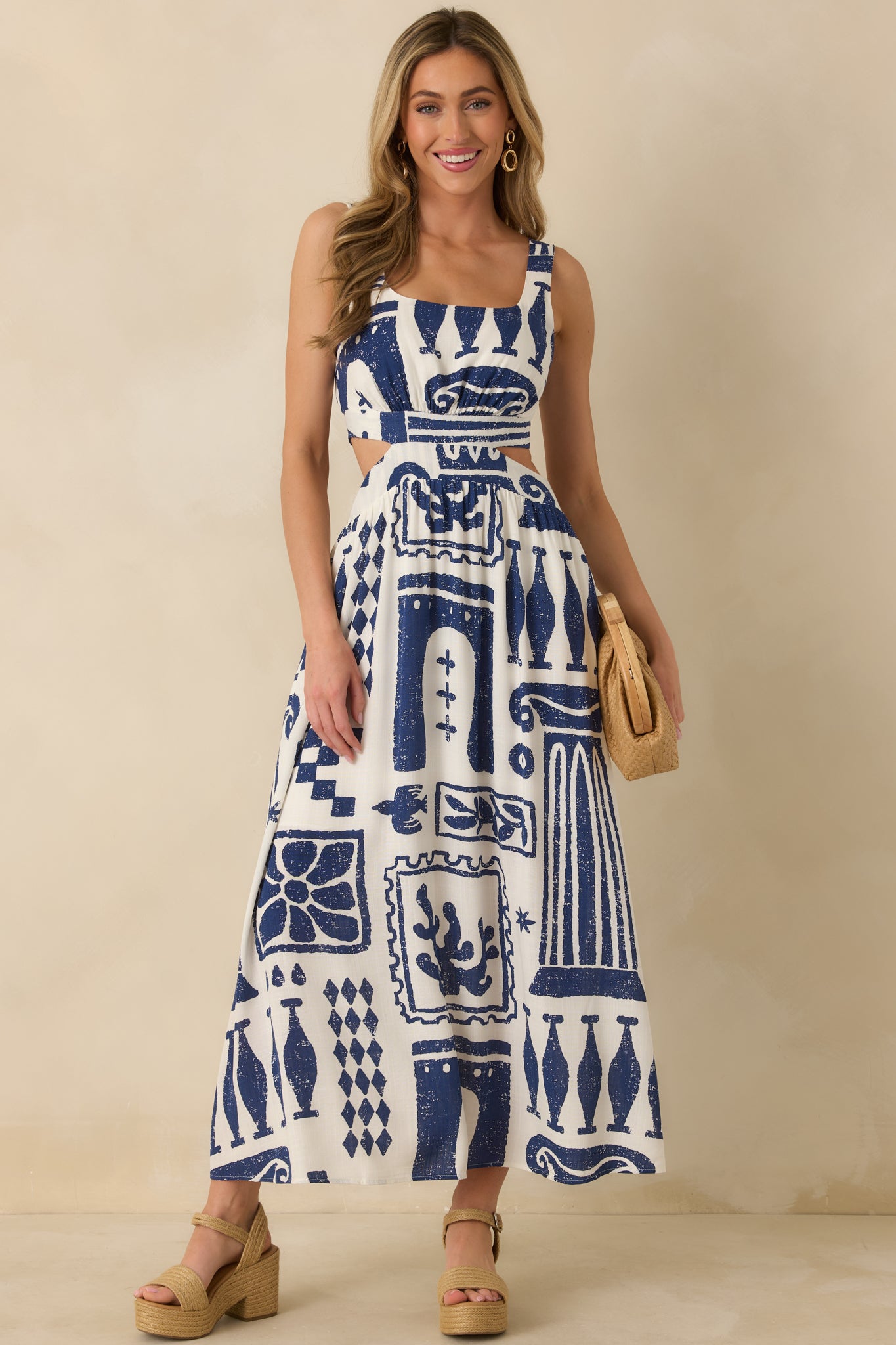 Full-length navy and white dress with fitted upper body, wide straps, and fluid skirt silhouette.