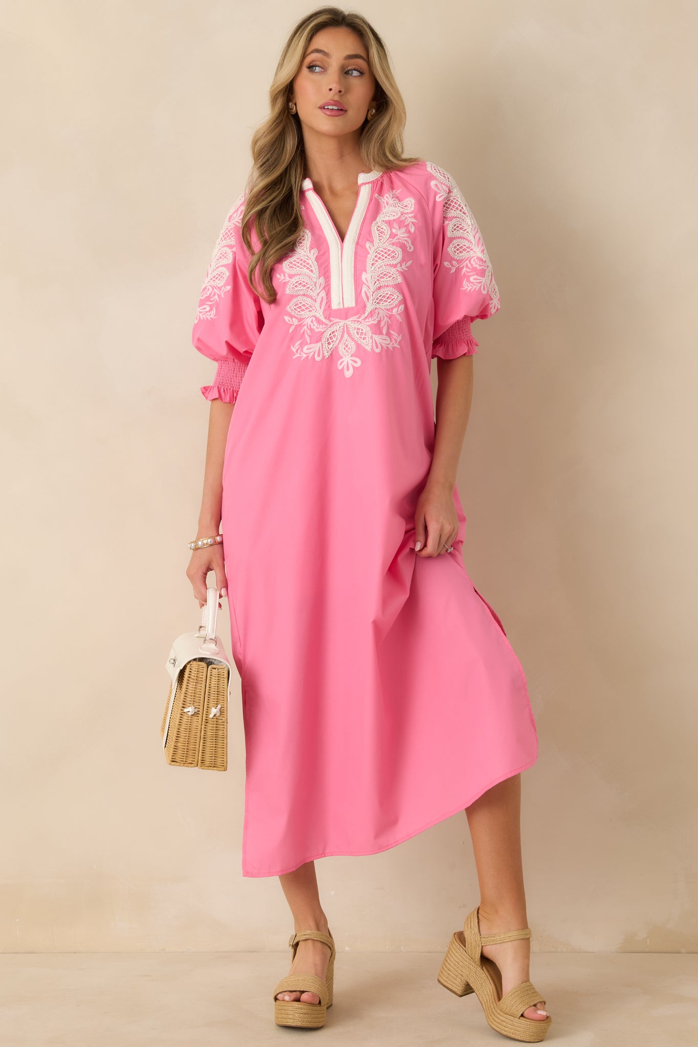 Full-length shot of pink dress showing lightweight woven fabric and side pockets for practical detail.