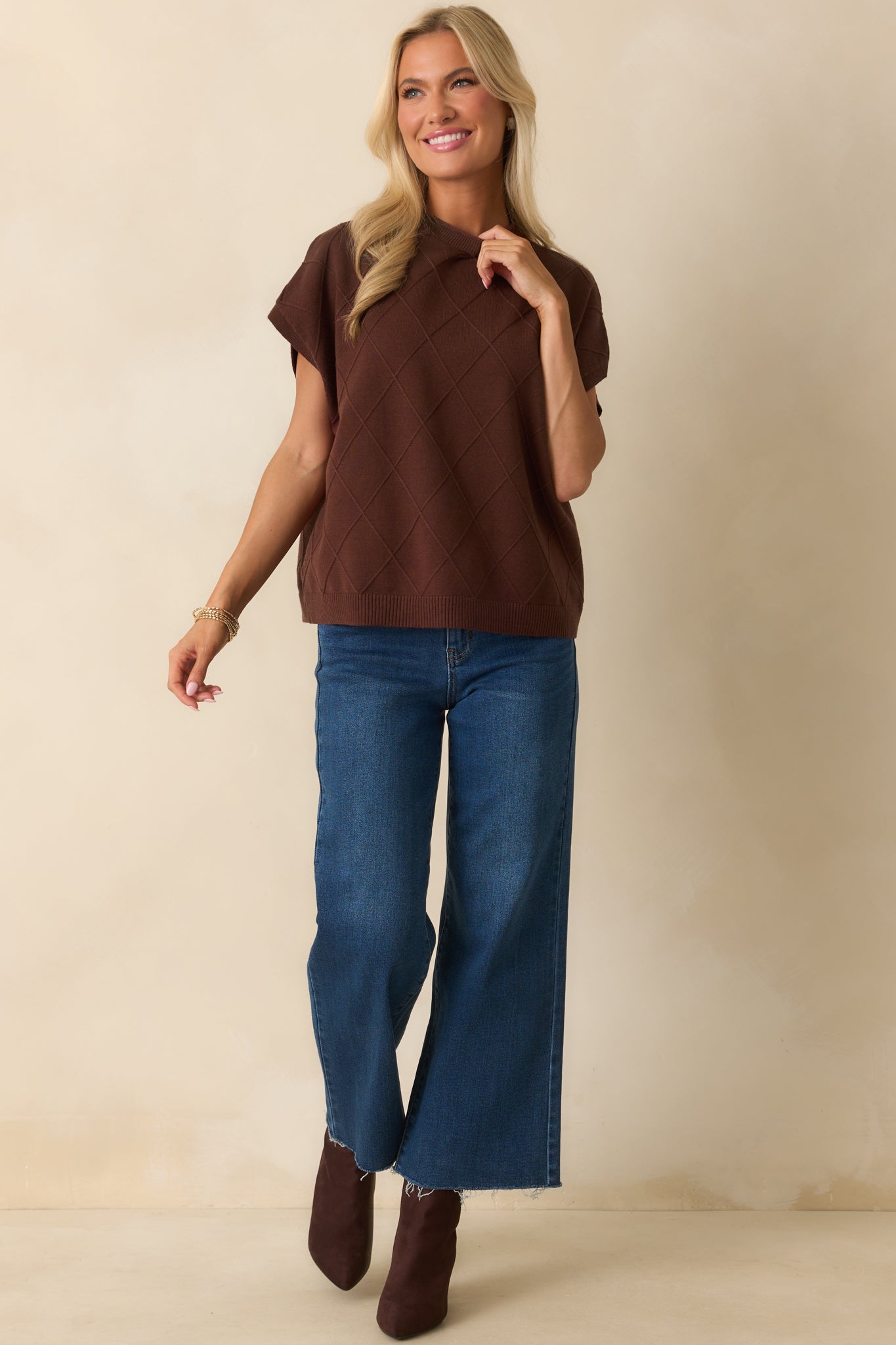 Full-length view of brown sweater emphasizing argyle texture and dolman sleeve shape.