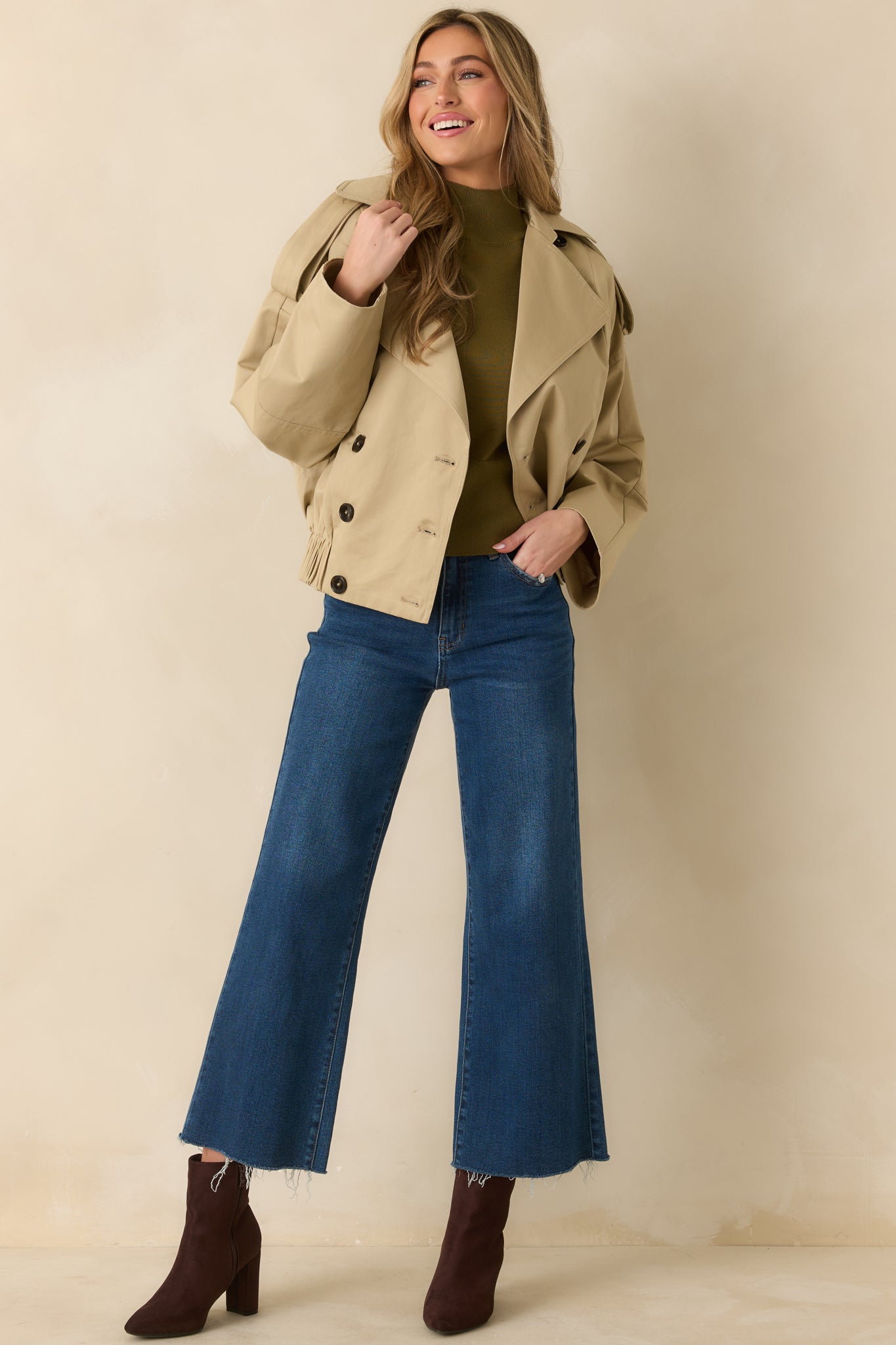 Full-length view highlighting long sleeves with buttoned cuffs, side pockets, and structured cropped shape.