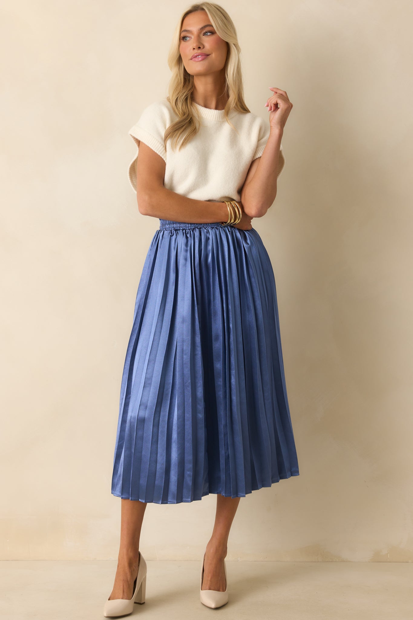 A full-length view showing the soft drape and structured pleats of the skirt.