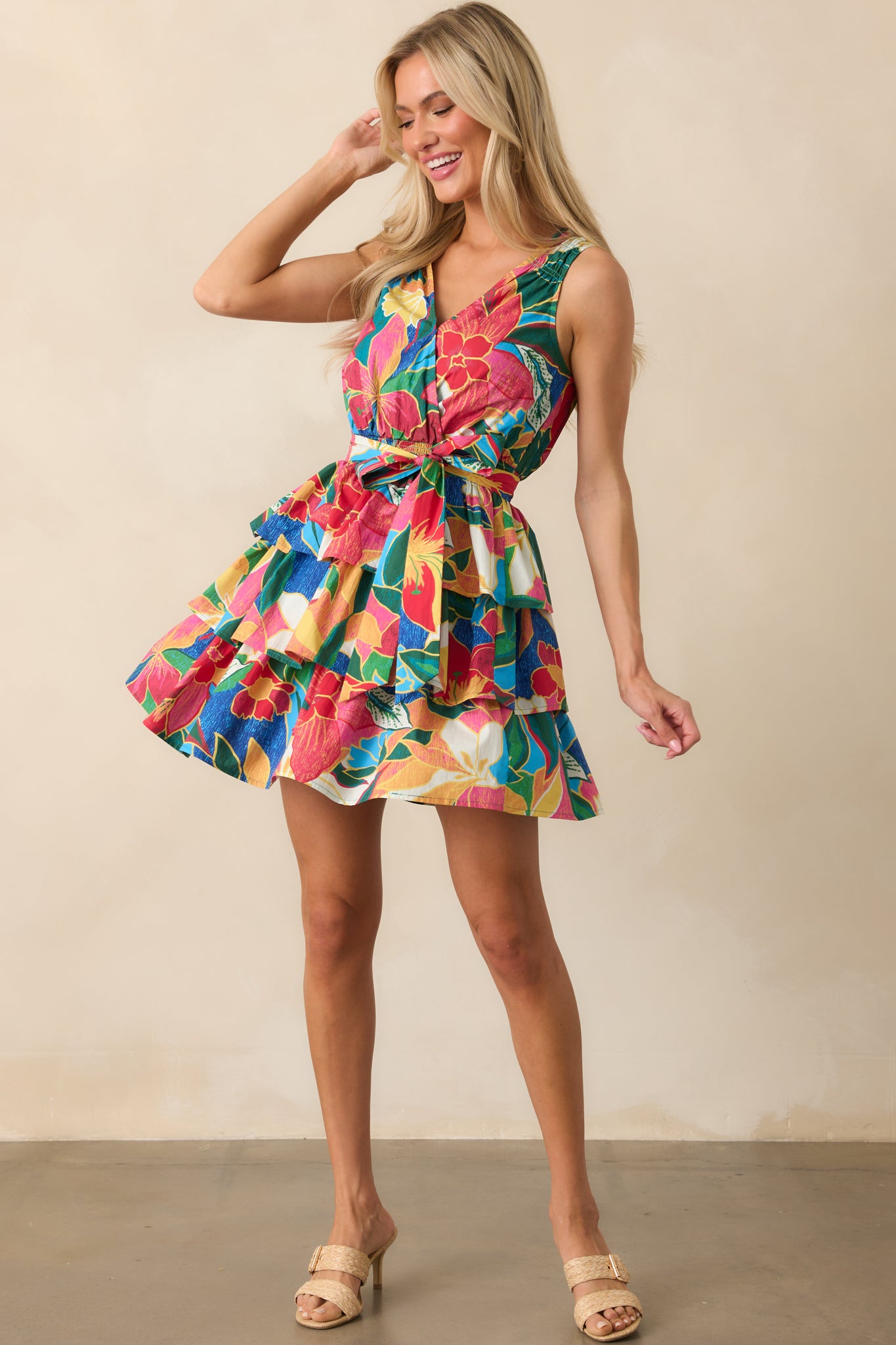 Full-length shot highlighting the layered tier skirt and sleeveless design of the tropical print mini dress.
