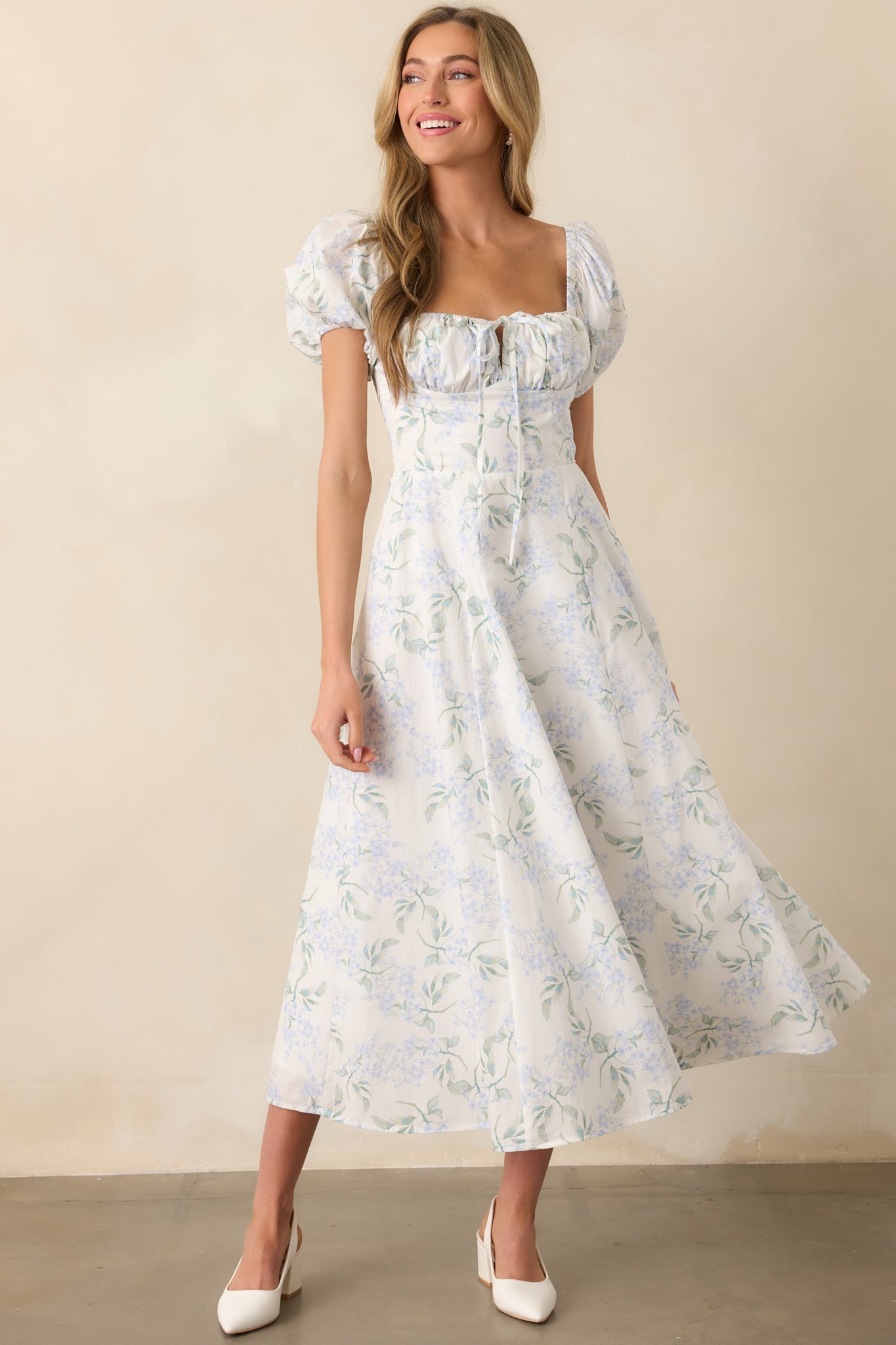 A full body shot of the light blue floral print maxi dress, showcasing the elastic sweetheart neckline, short puff sleeves, and elastic cuffs. The bustier-style bodice is elegantly designed, offering a fitted silhouette.