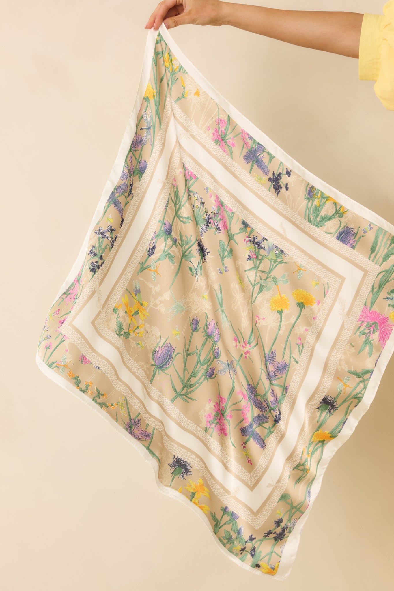 Full view of a beige square scarf featuring a multicolor floral design and animal print border.