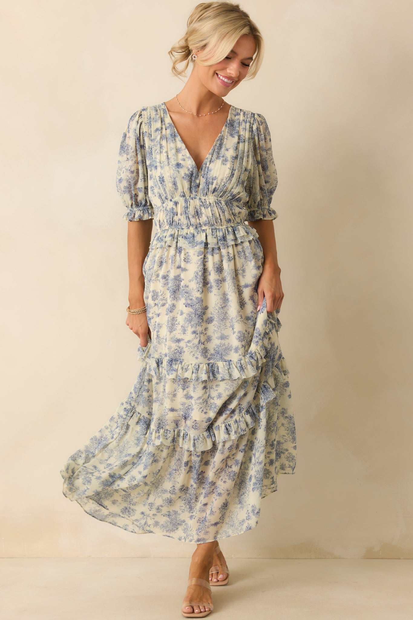 Full view of the blue maxi dress with v-neckline and floral pattern, showcasing the puff sleeves with elastic cuffs.