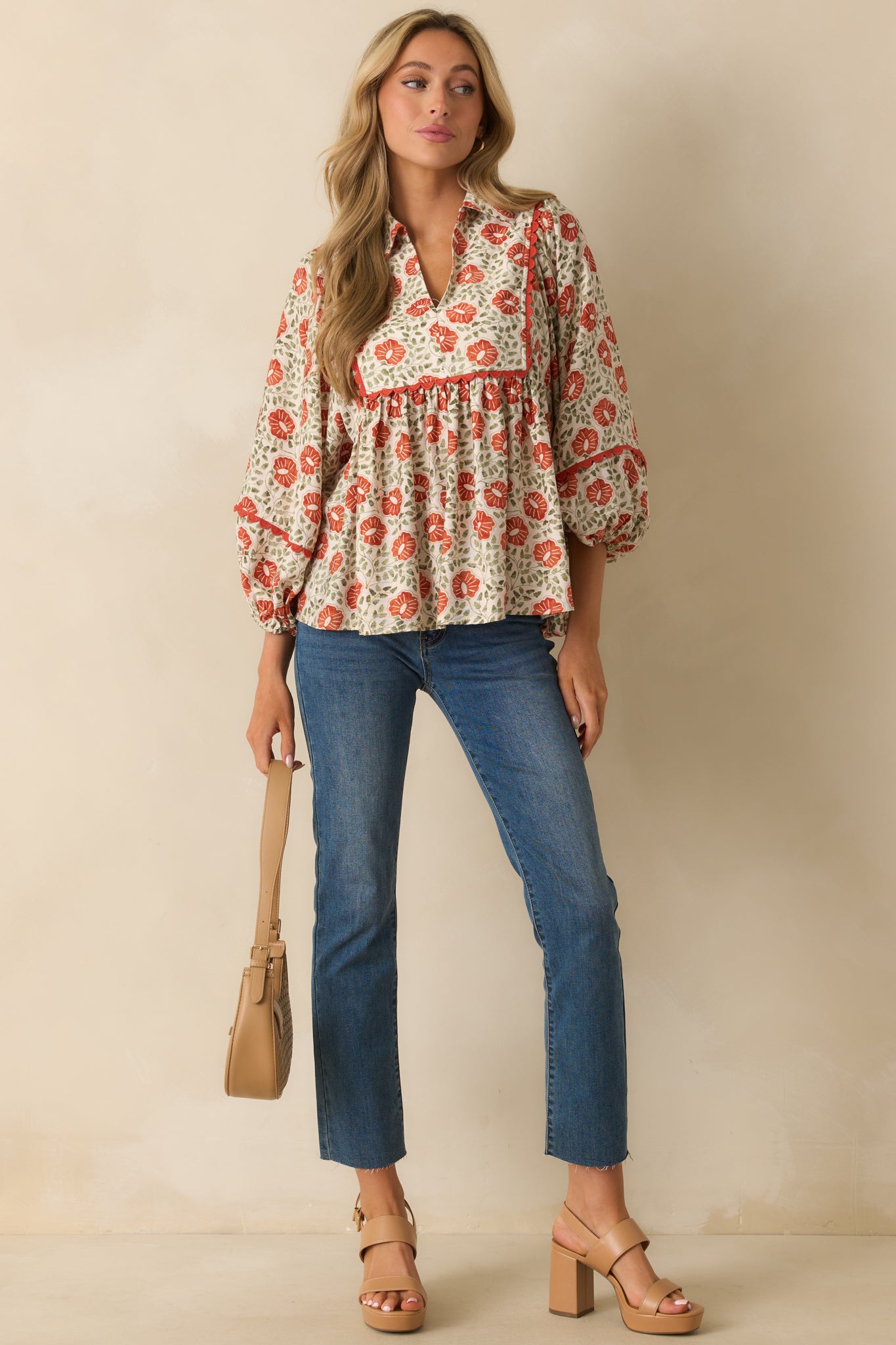 A full view of the burnt orange floral top with a collared notch V-neckline and relaxed fit.