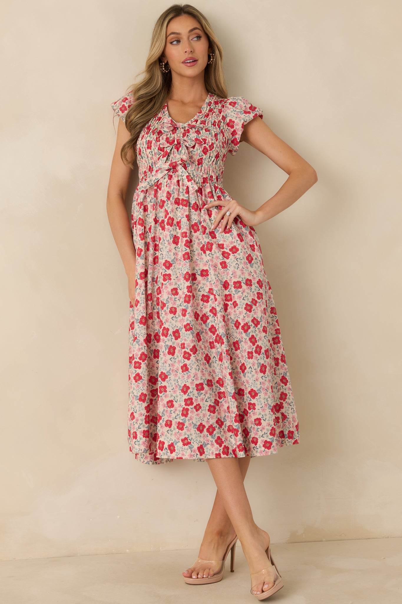 Full length front view focusing on the flutter sleeves and vibrant red floral print.