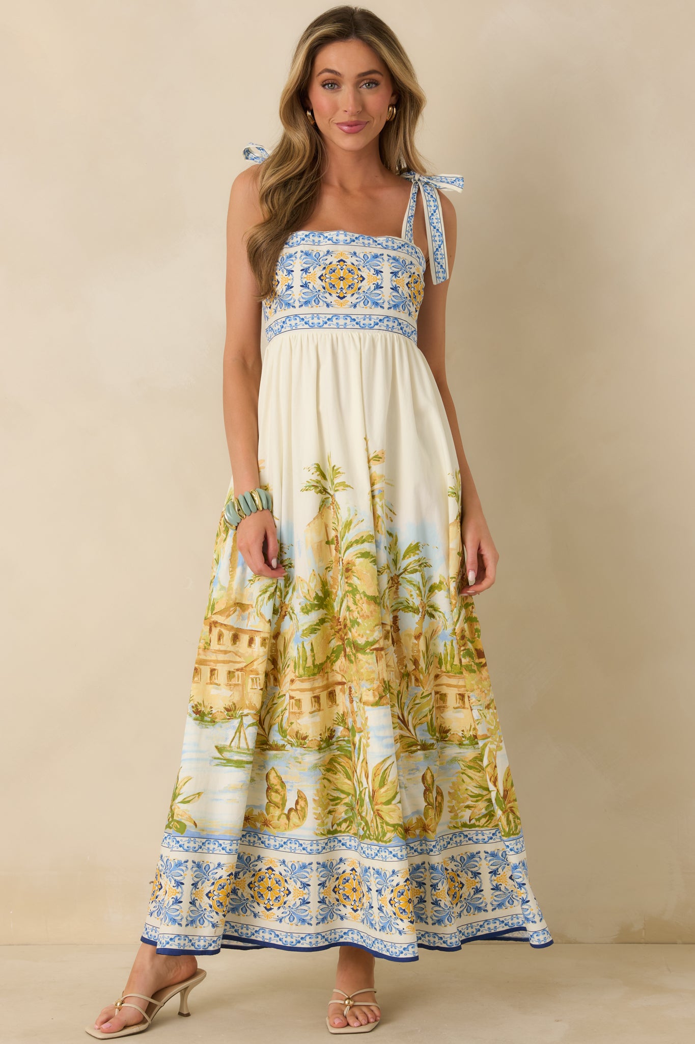 Flowing full-length maxi dress featuring multicolor scenic print and contrast border accents.