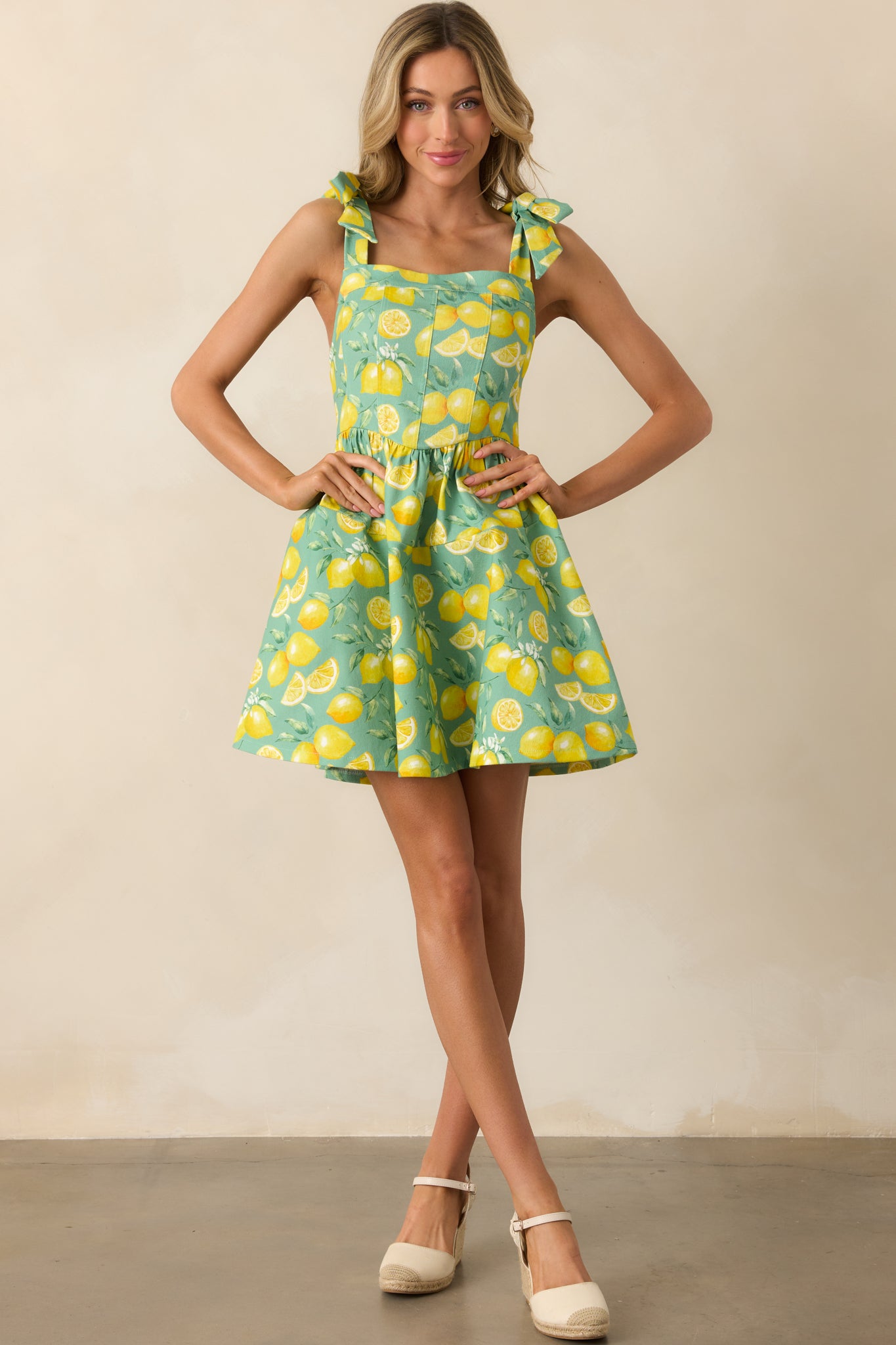 Mini dress displayed in a full view, highlighting the drop waist silhouette and allover lemon pattern.