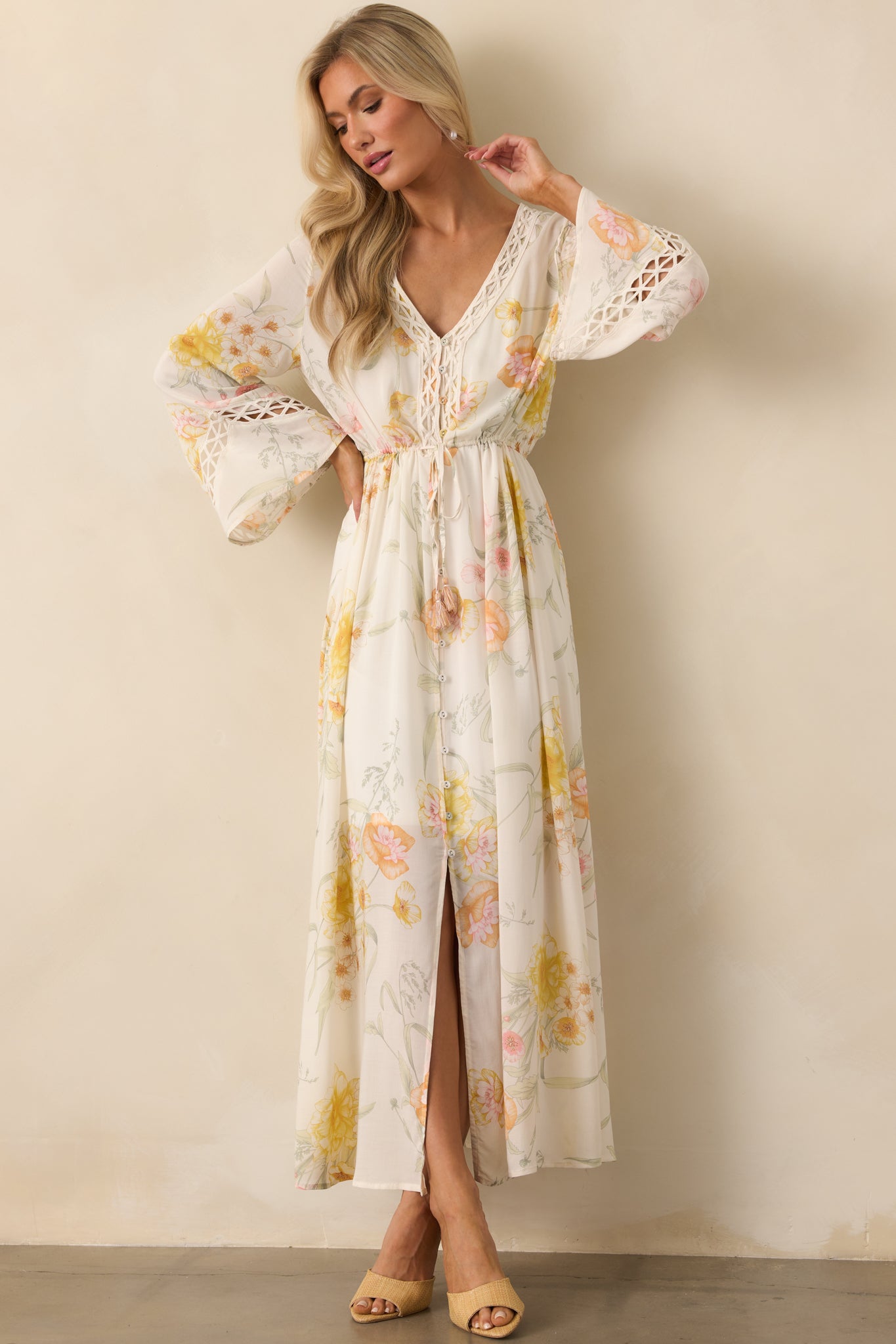 Front-facing full view of the ivory maxi dress featuring a yellow multicolor floral print, V-neckline, and flowy long sleeves.