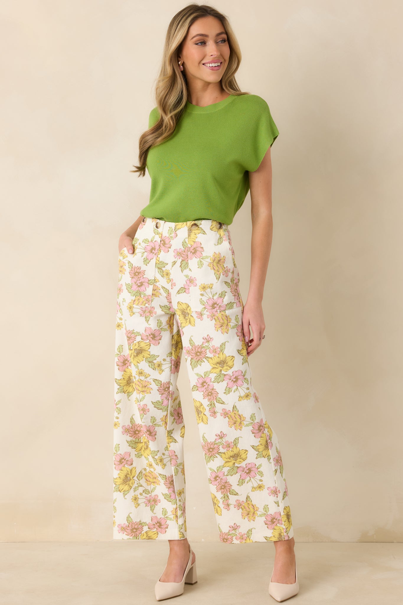 Full-length front view of the ivory pants showcasing the pink and yellow floral print and wide leg silhouette.
