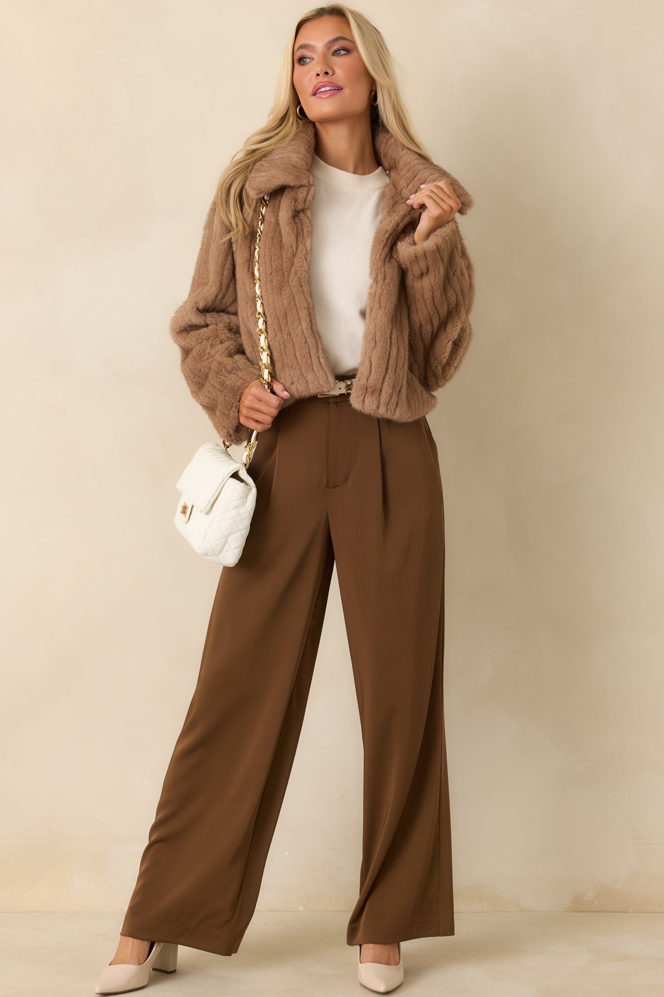 Soft mocha brown faux fur jacket showing the ribbed surface, wide collar shape, and clean front closure detail in a relaxed cropped silhouette.