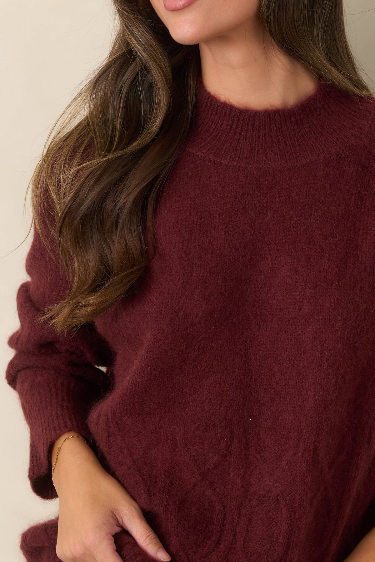 Close-up of the fuzzy knit texture highlighting the intricate cable detailing and ribbed mock neckline.