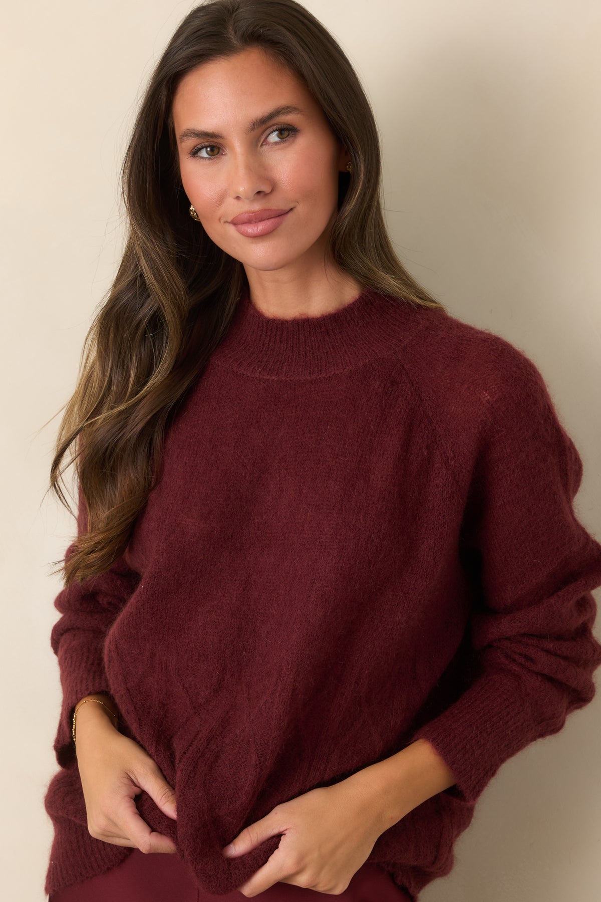 Soft fuzzy knit top highlighting the ribbed mock neckline and relaxed raglan sleeve construction.