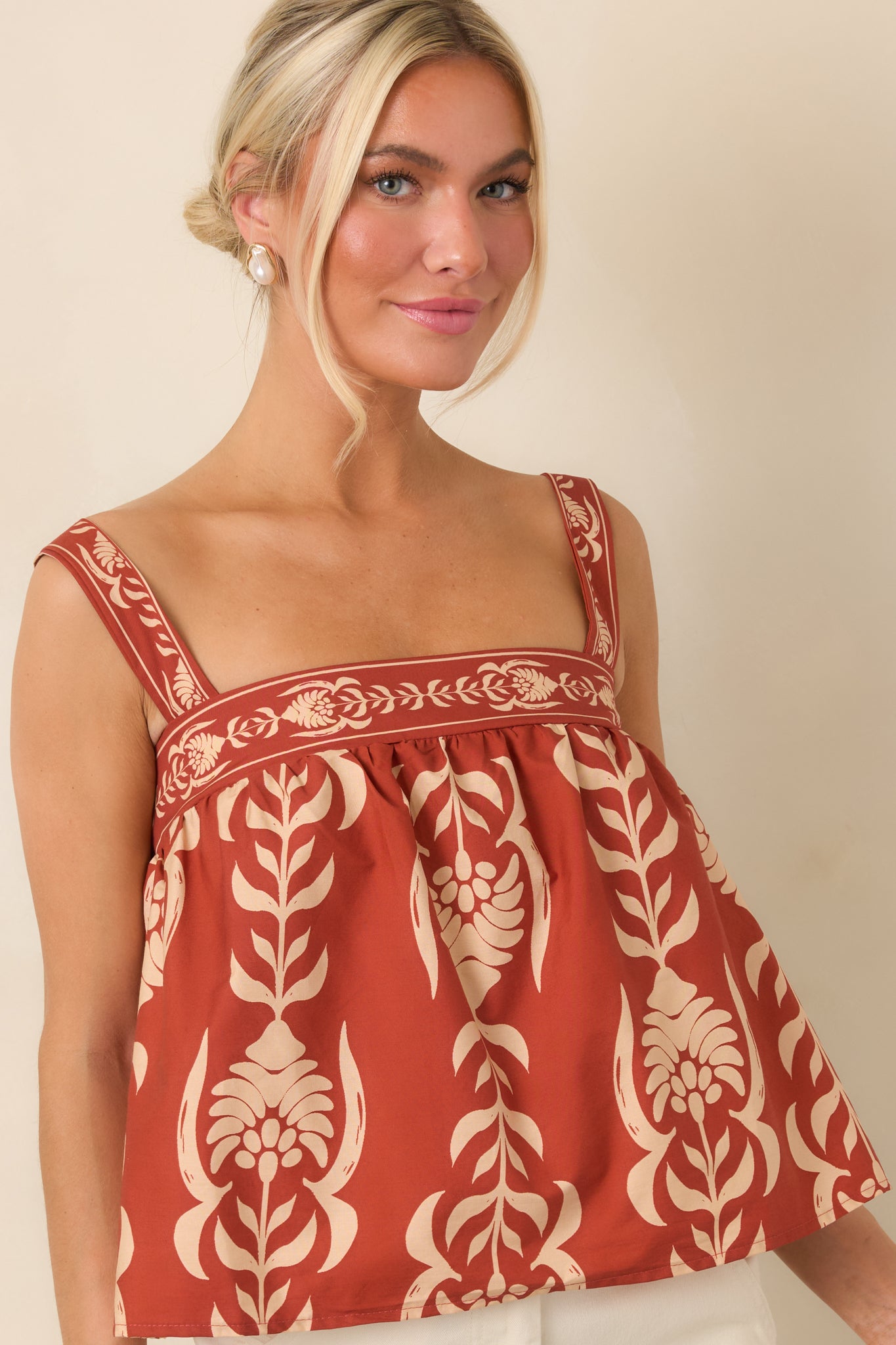 Gathered cotton fabric creates a softly textured babydoll silhouette beneath the clean square neckline.