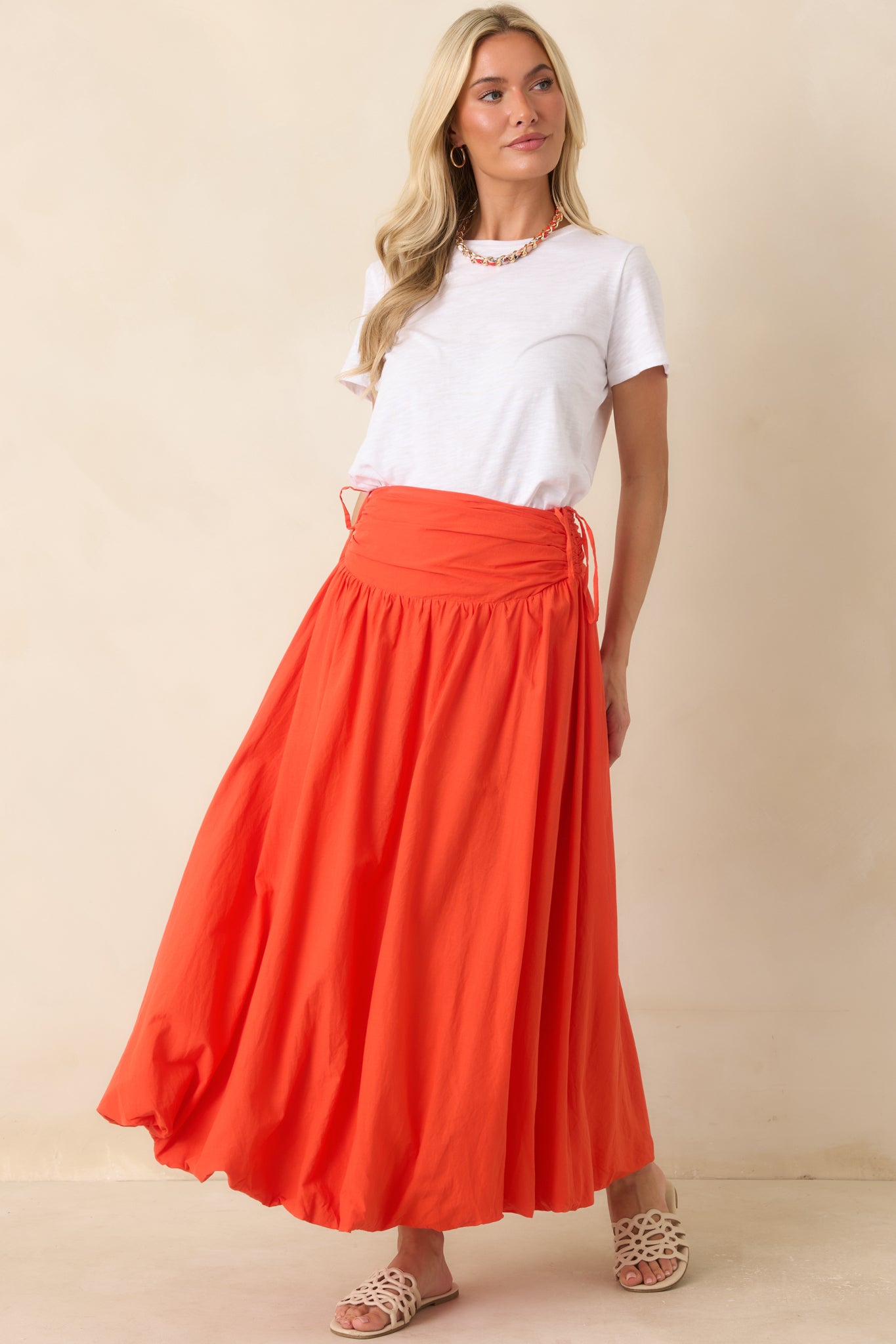 Coral orange cotton maxi skirt designed with a gathered waistband, adjustable side ties, and a sweeping silhouette that moves beautifully.