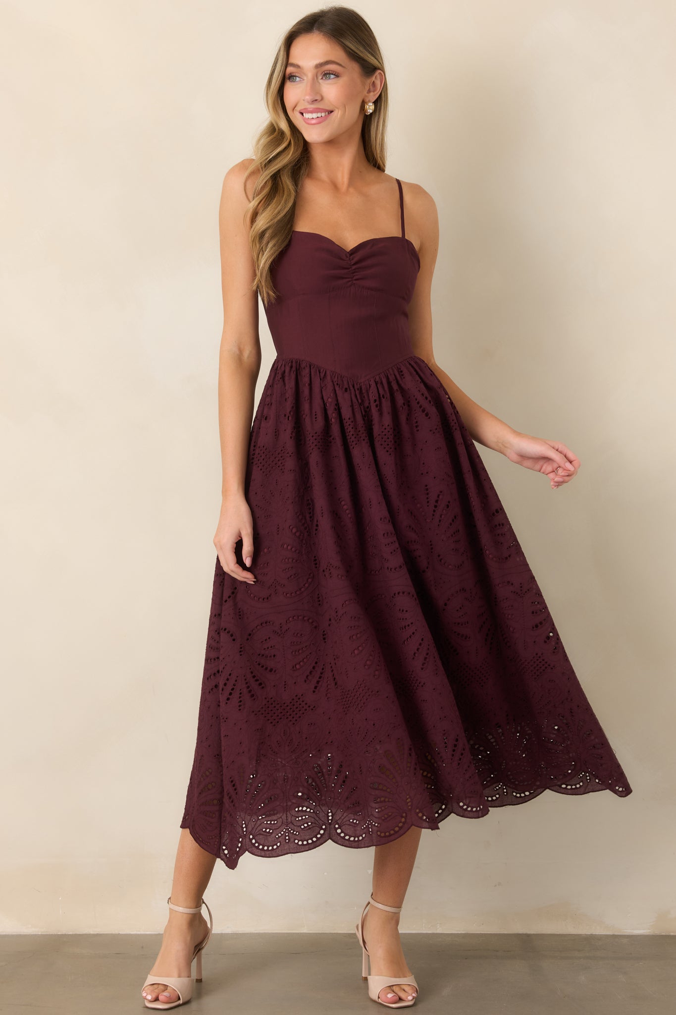 Eyelet midi dress showcasing its shaped bodice, gathered skirt, delicate scalloped hem, and feminine flared silhouette.