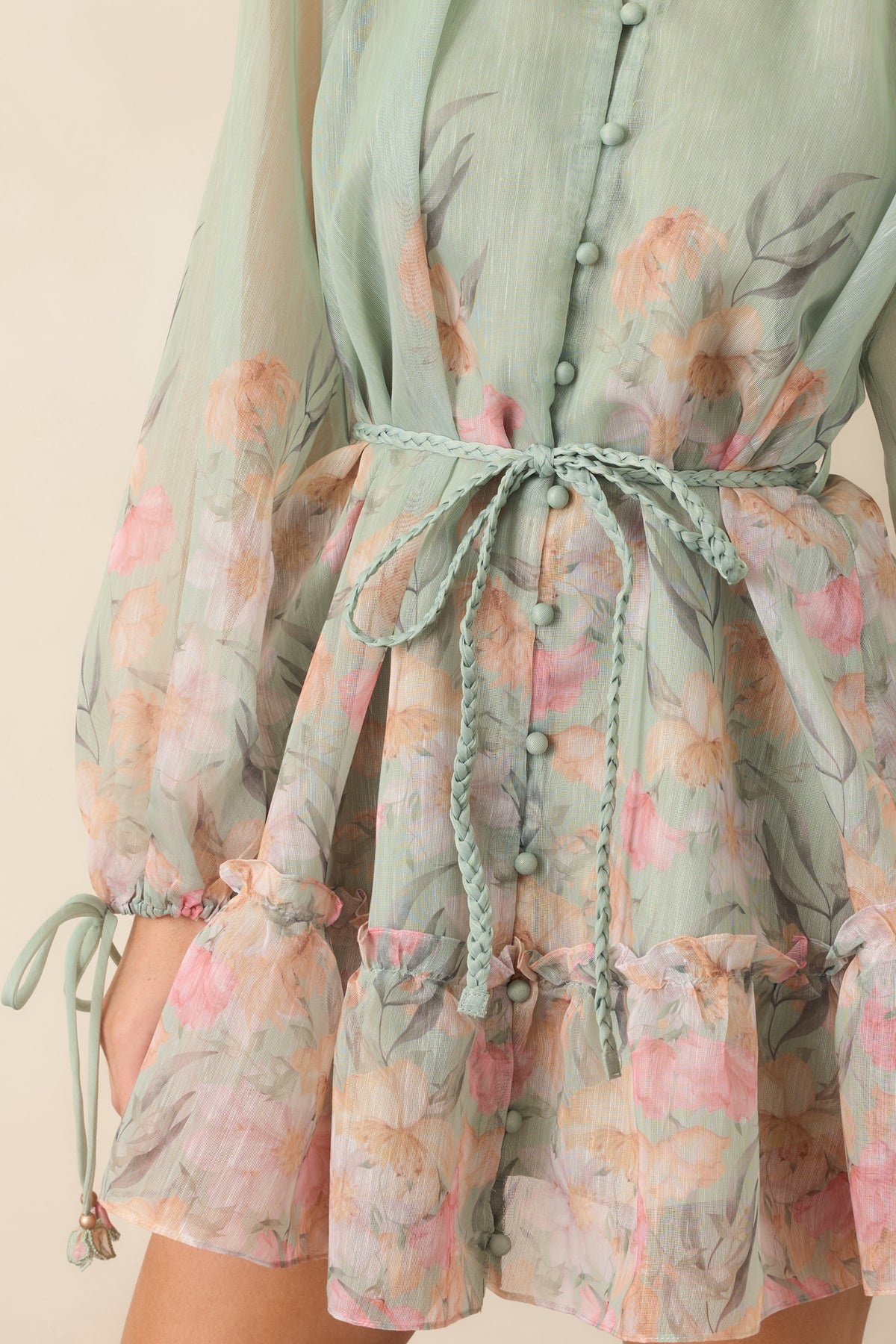 Gathered split neckline with fabric-covered buttons and floral-accented tie cuffs.