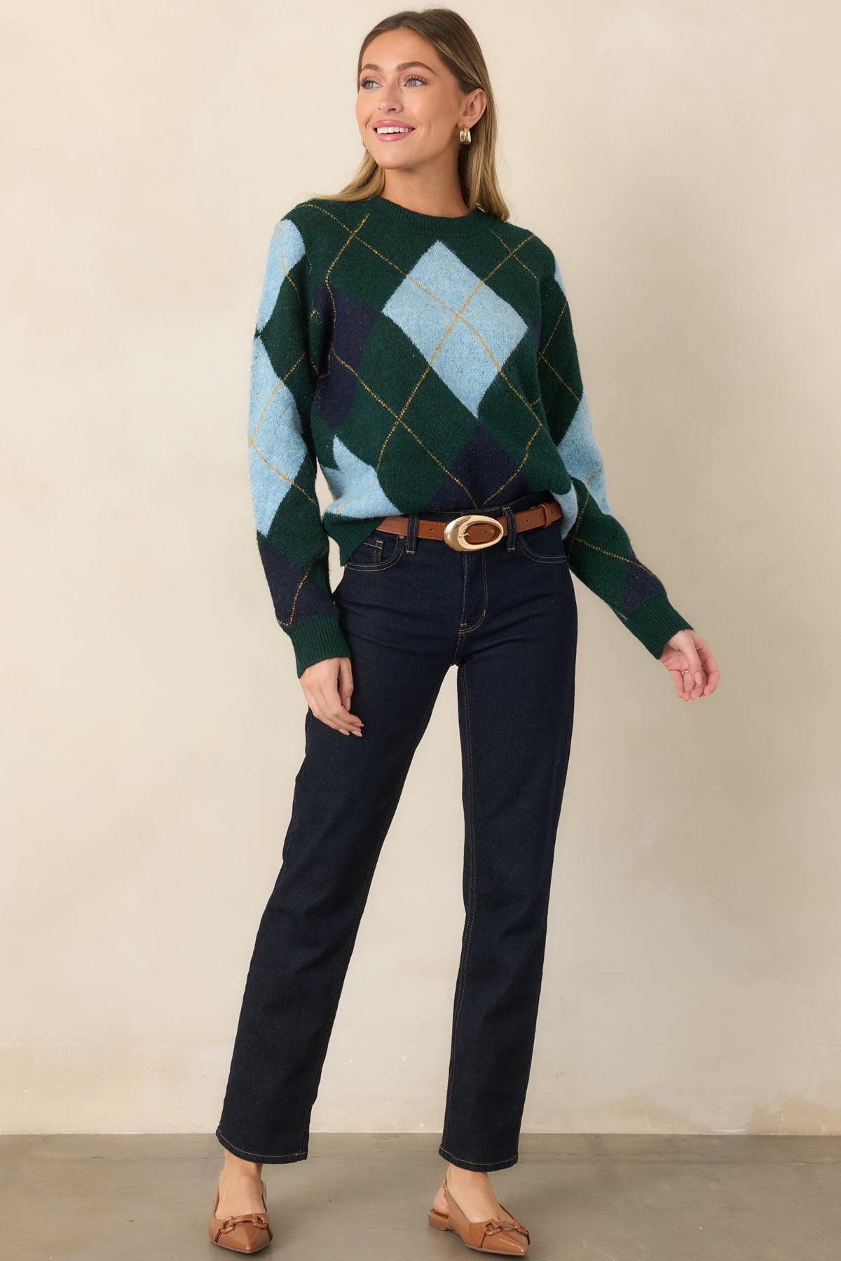 Geometric knit sweater defined by its dark green ground, light blue and navy diamond design, long sleeves, and comfortable ribbed finishes.