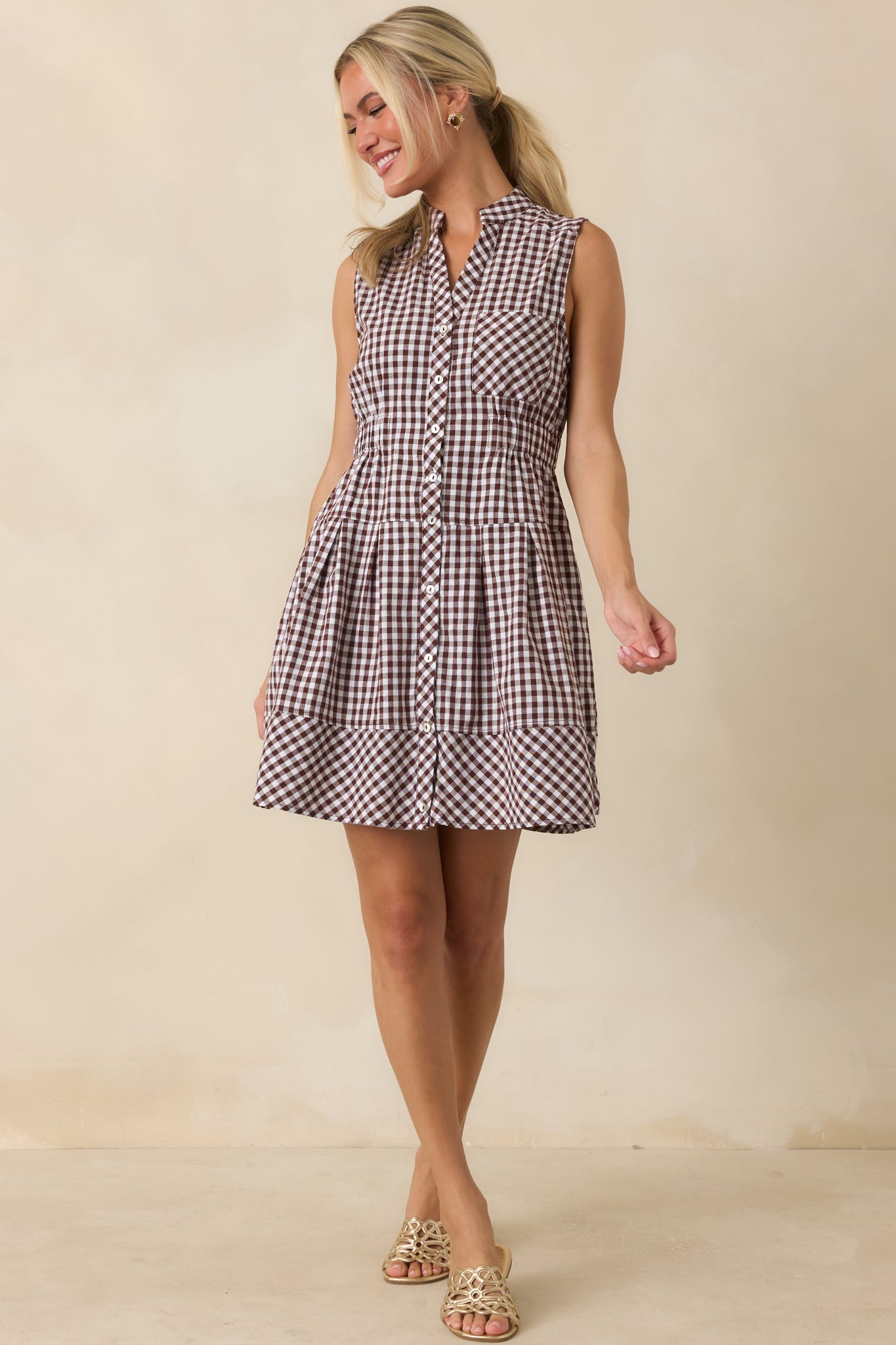 Lightweight gingham mini dress showcasing a collared neckline, button-front design, hidden side pockets, and an easy fit.