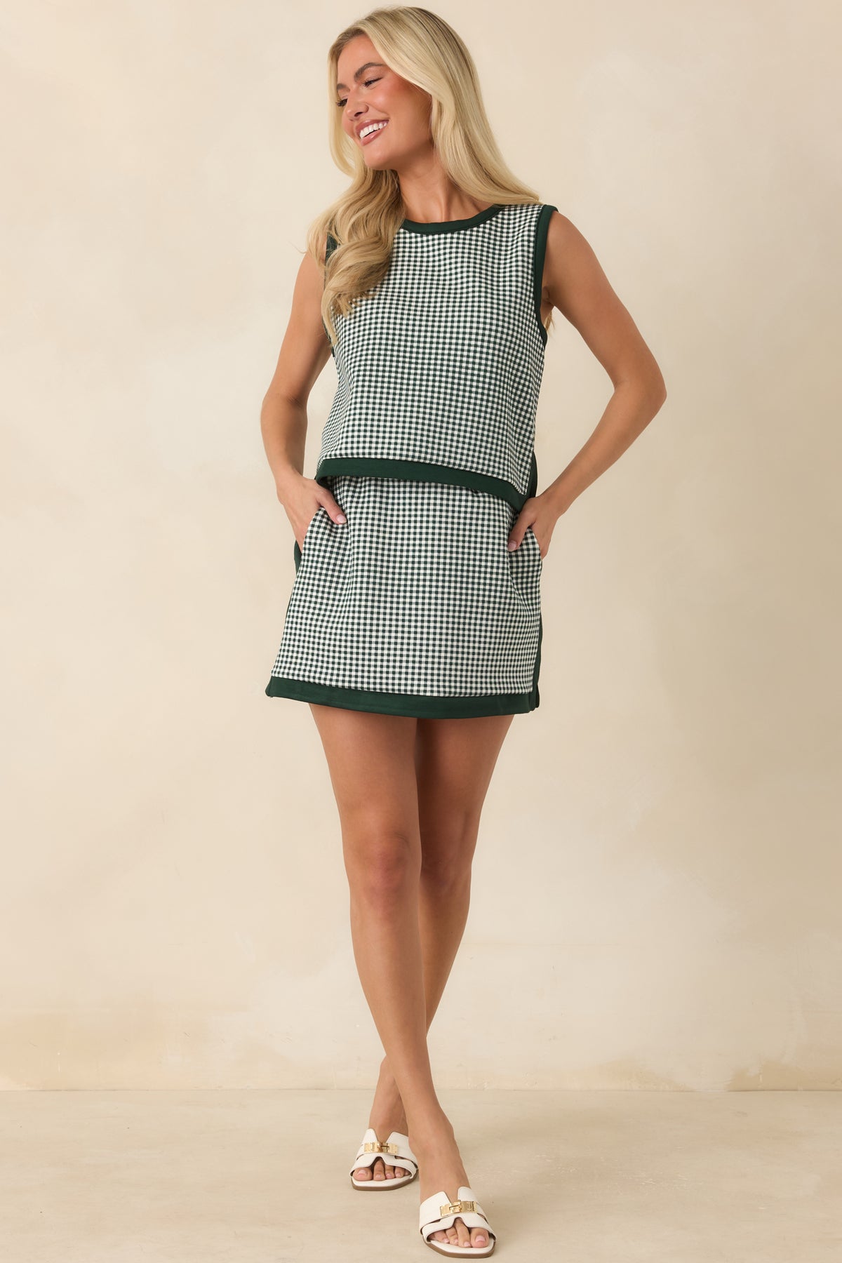 Hunter green and ivory gingham mini skirt featuring solid trim accents, built-in shorts, and a structured silhouette.