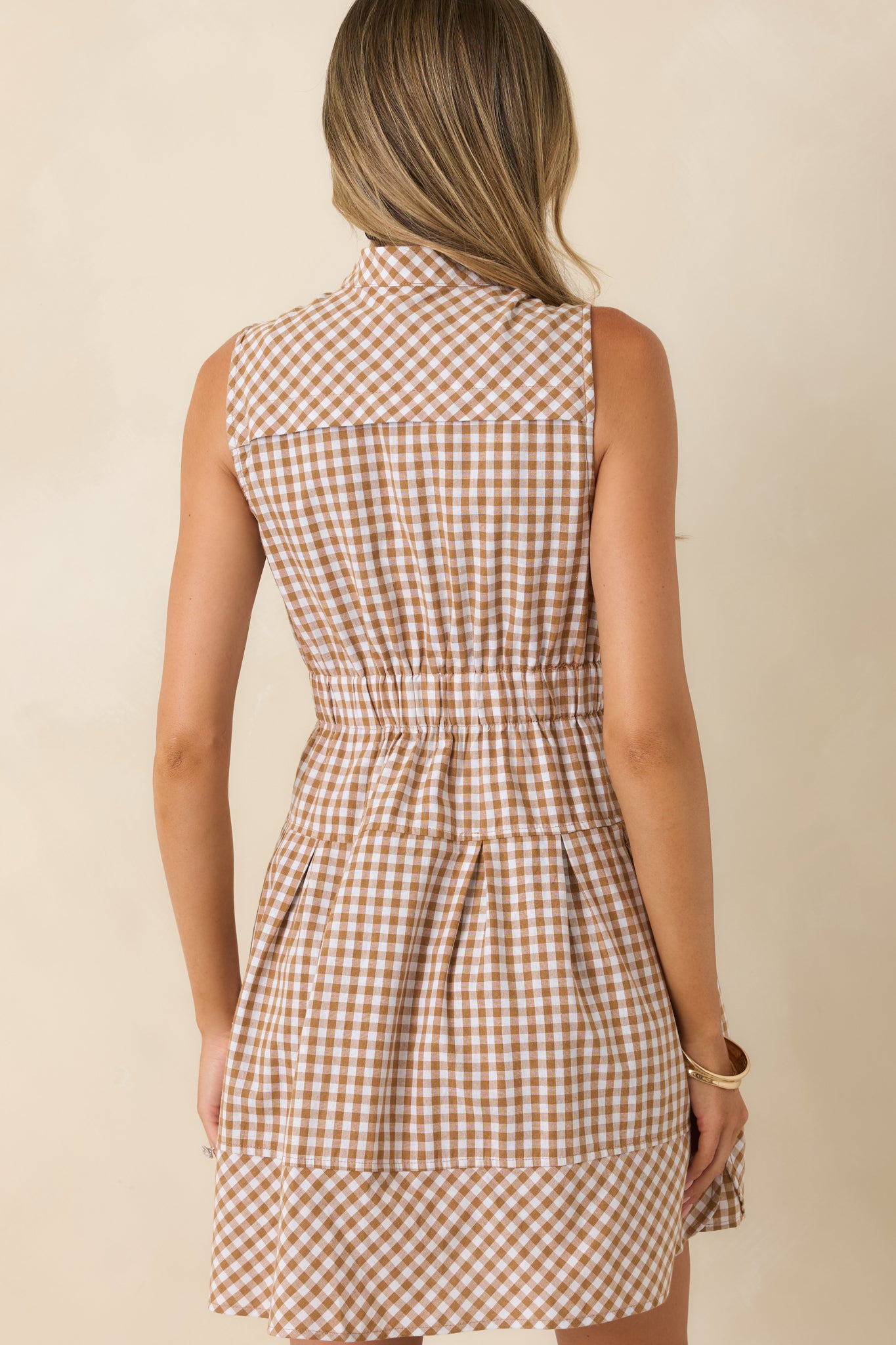 Rear view of the gingham mini dress featuring a relaxed silhouette, elastic waistband, and clean tailored finish.