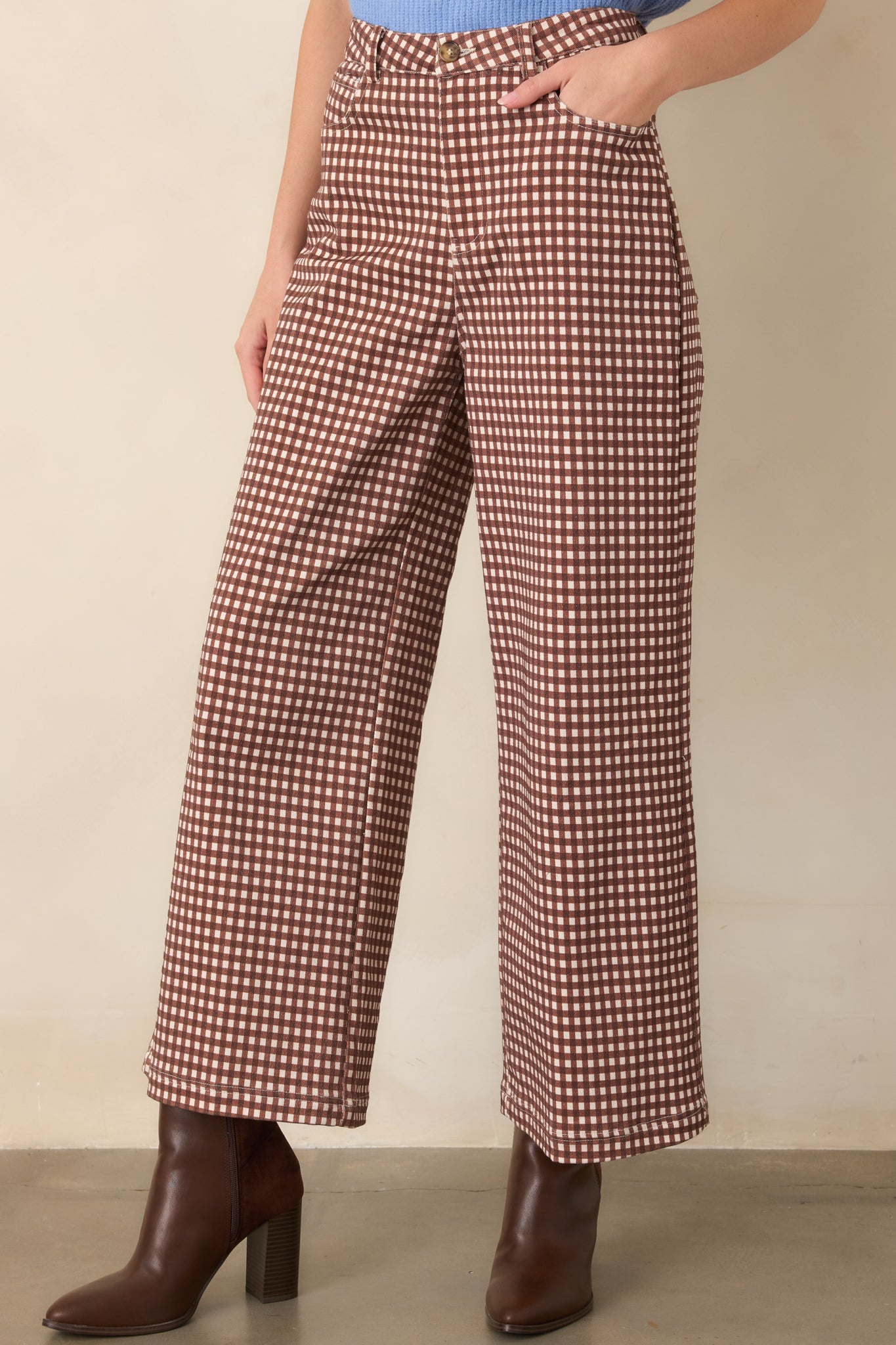 Detailed view of the gingham trousers showcasing their soft stretch fabric, functional front pocket, and relaxed wide-leg construction.
