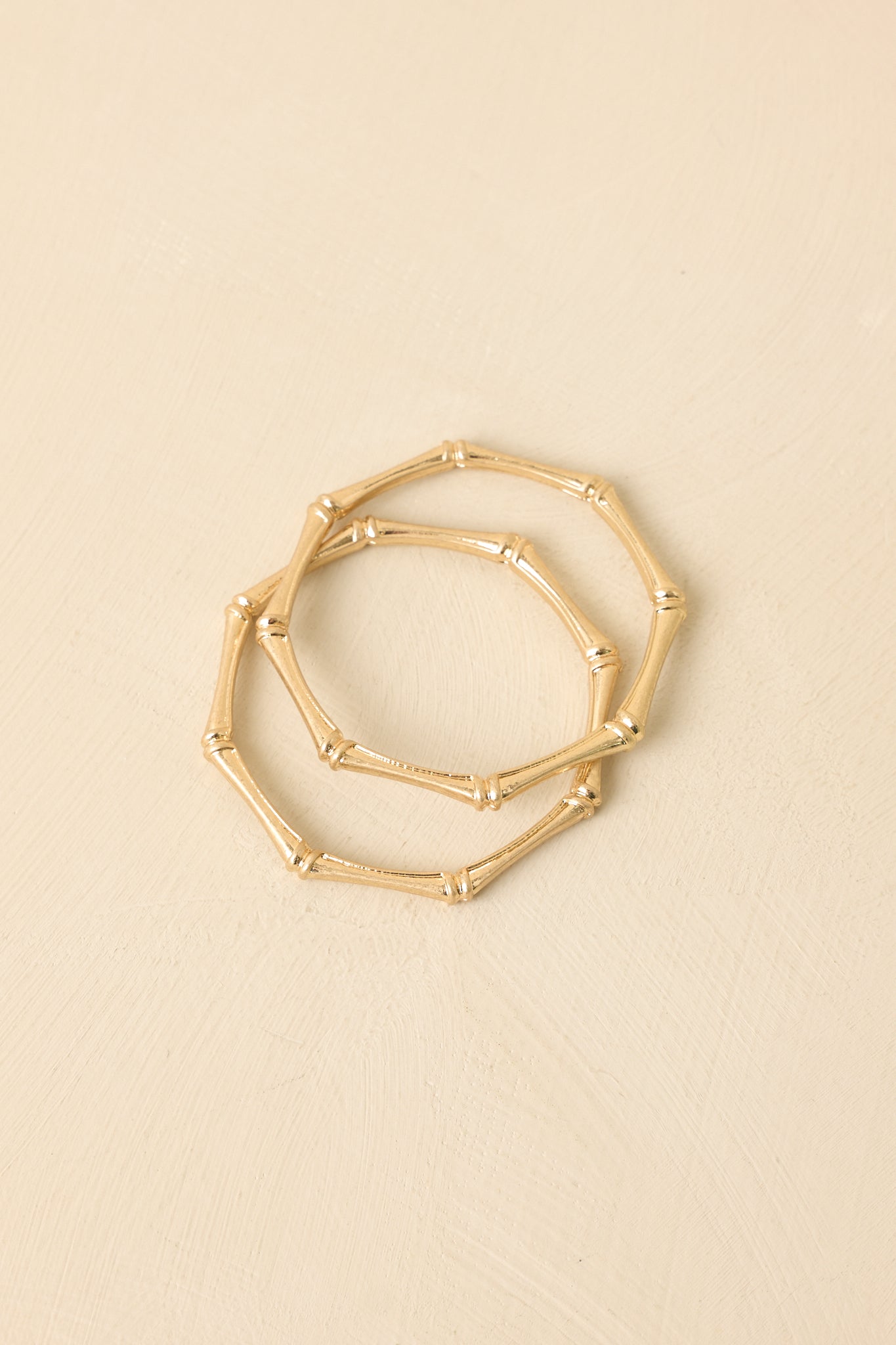 Close-up of gold bamboo bangles showing polished finish, textured design, and refined structured detailing for modern elegance.