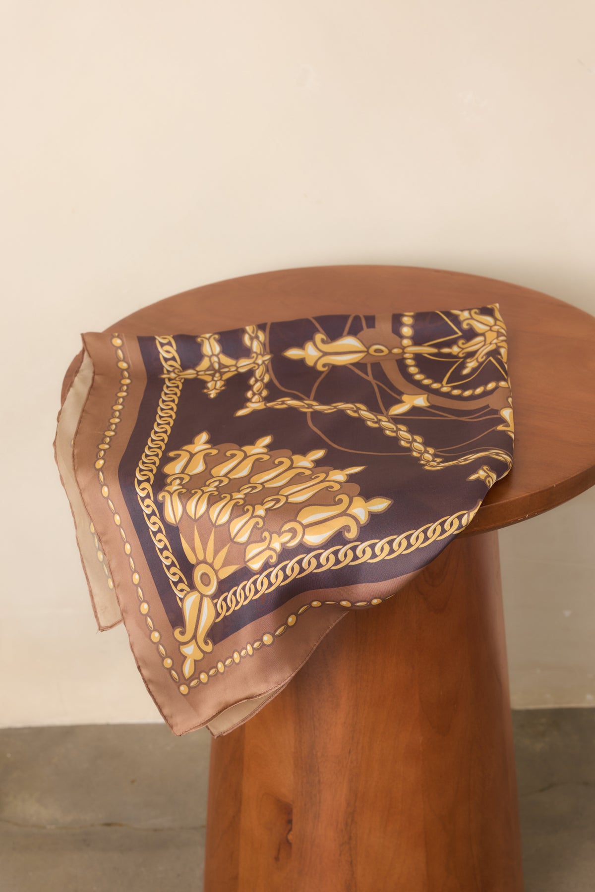 Close-up detail of the scarf's ornate gold chain motifs and decorative medallion pattern.