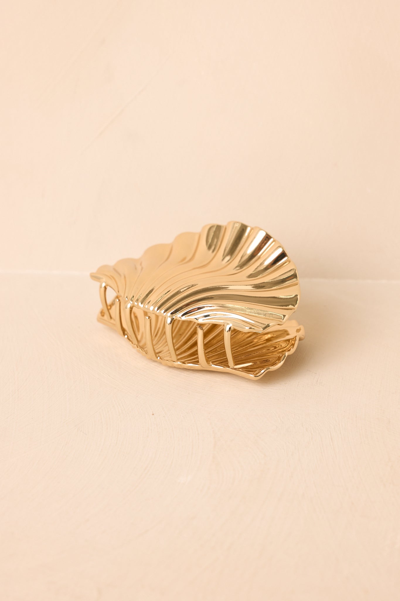Back view of the gold claw hair clip showing the curved structure and secure gripping teeth.