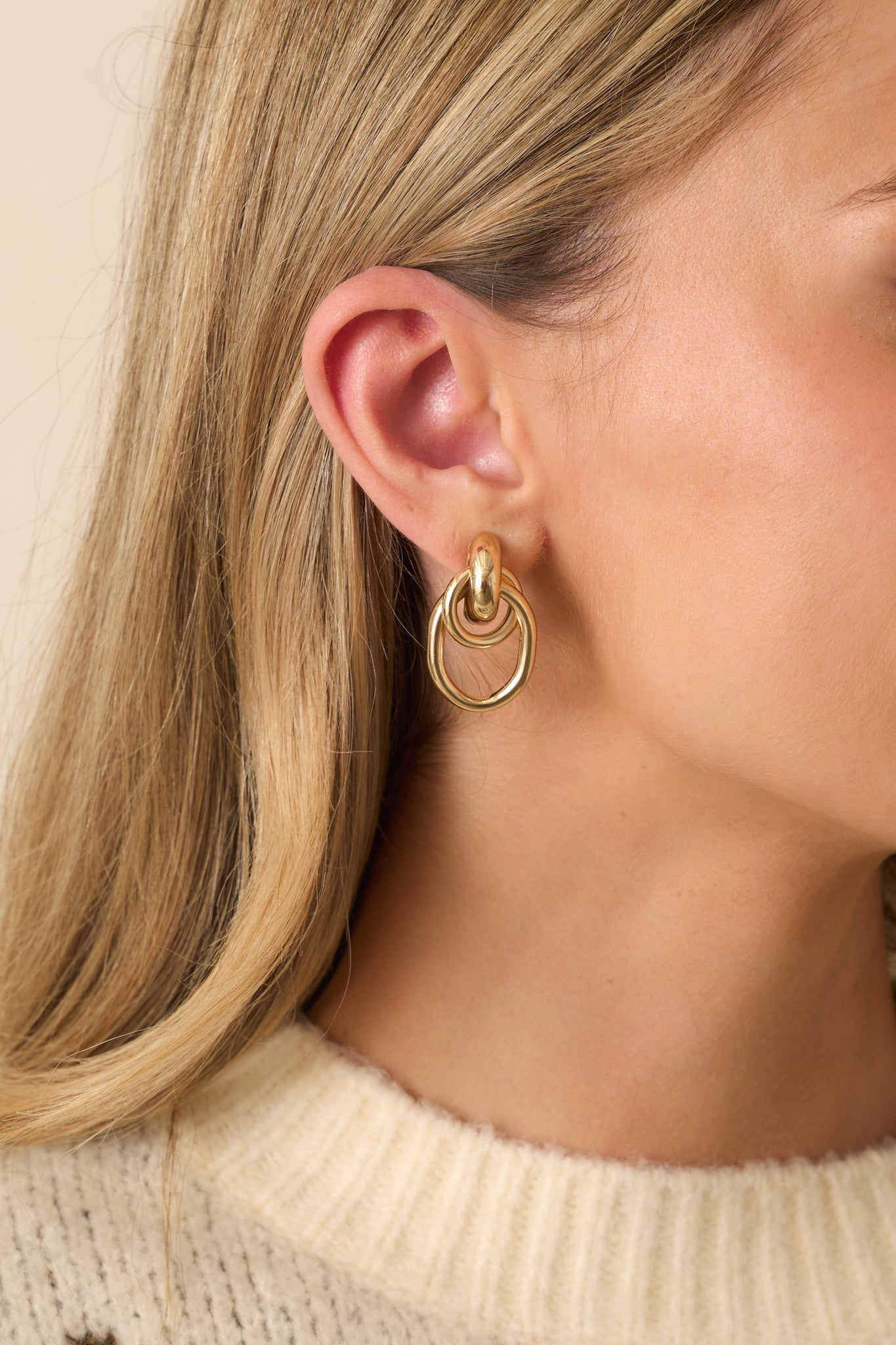 Gold-colored double hoop earrings shown in a cropped view highlighting their circular shape.