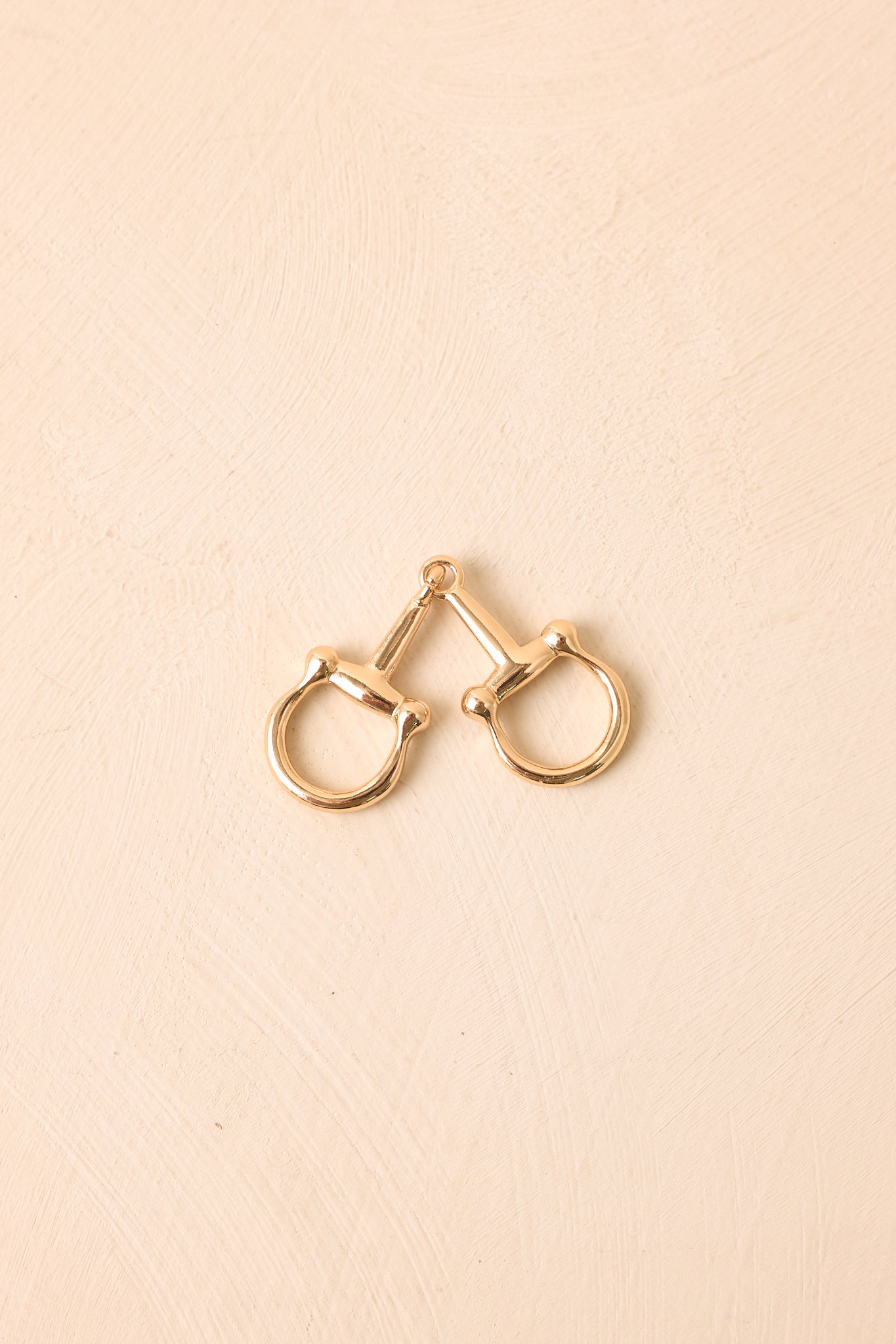 Polished gold-tone scarf ring featuring a sleek double horsebit design with an elegant equestrian-inspired finish.