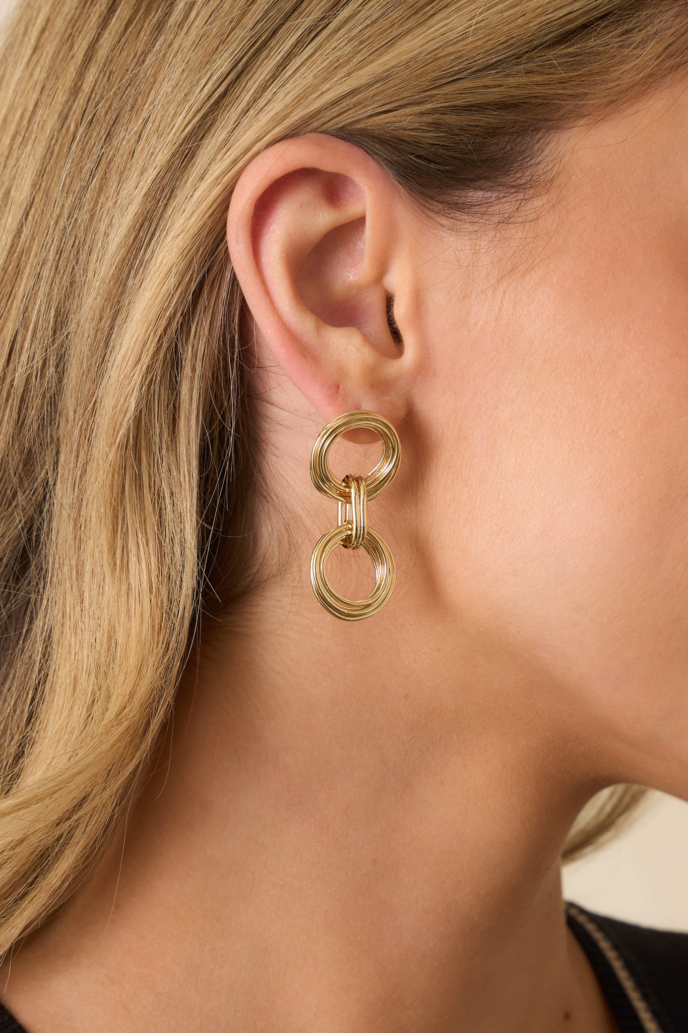 Gold drop earrings with interlocking circular links and a radiant, textured finish.