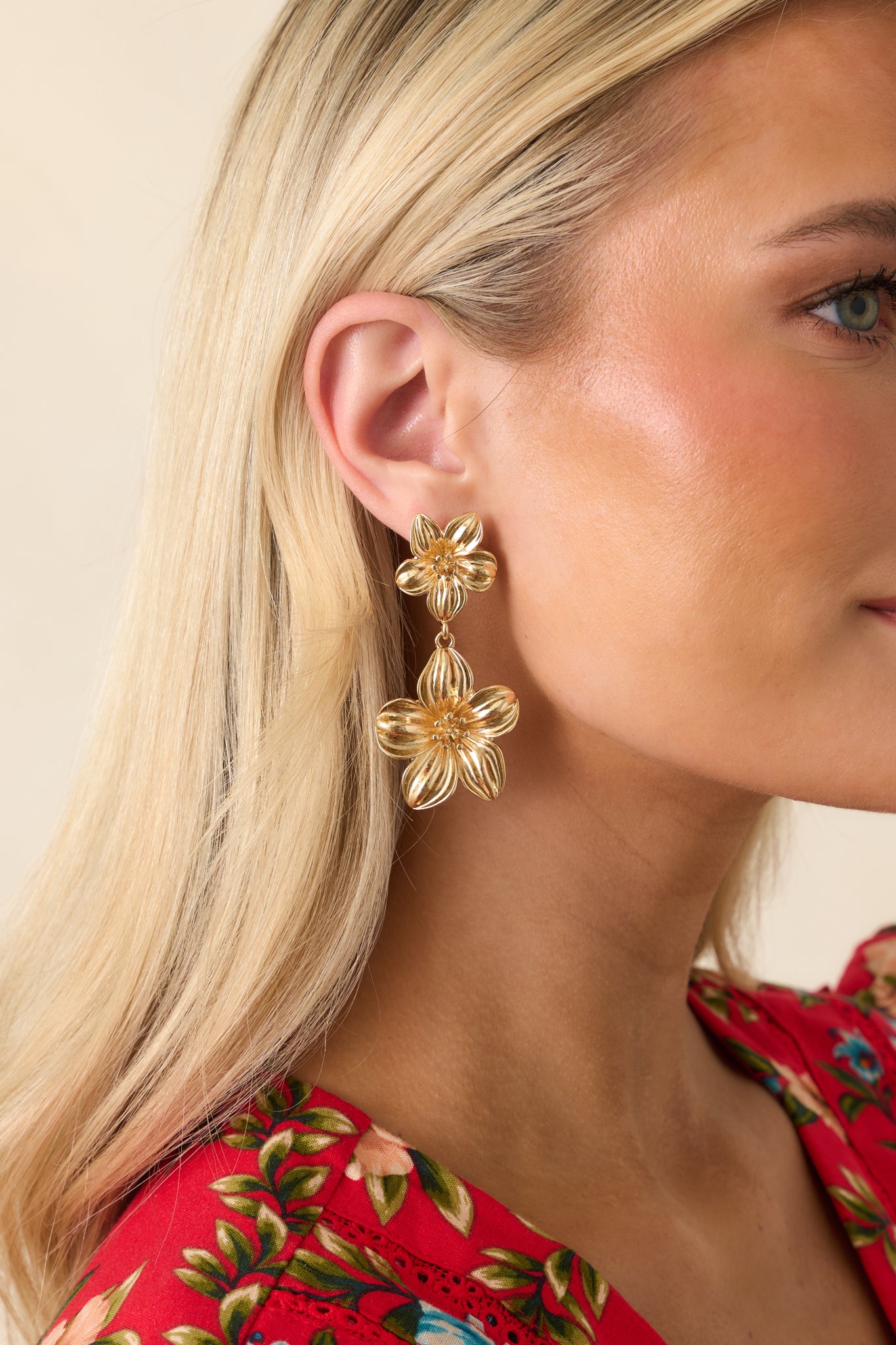 Gold flower earrings featuring a floral stud top, matching drop design, and secure post backing.