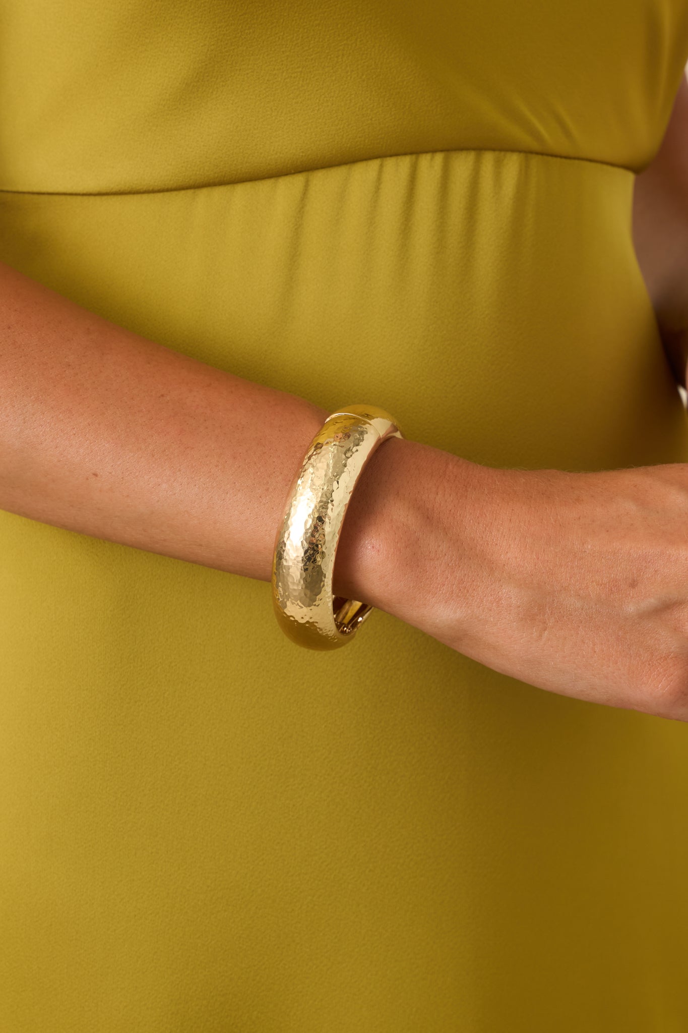 Gold hammered hinged cuff bracelet featuring a bold sculptural silhouette and organic textured finish.