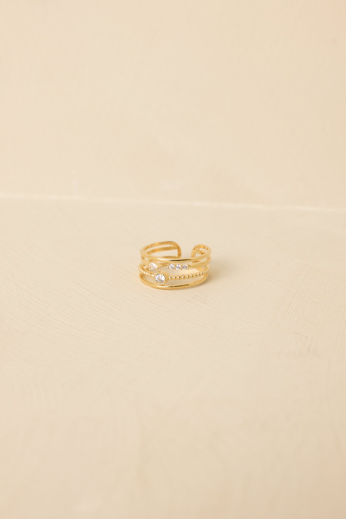 Close-up of gold layered ring emphasizing joined bands and tiny rhinestone accents for a modern, elegant finish.