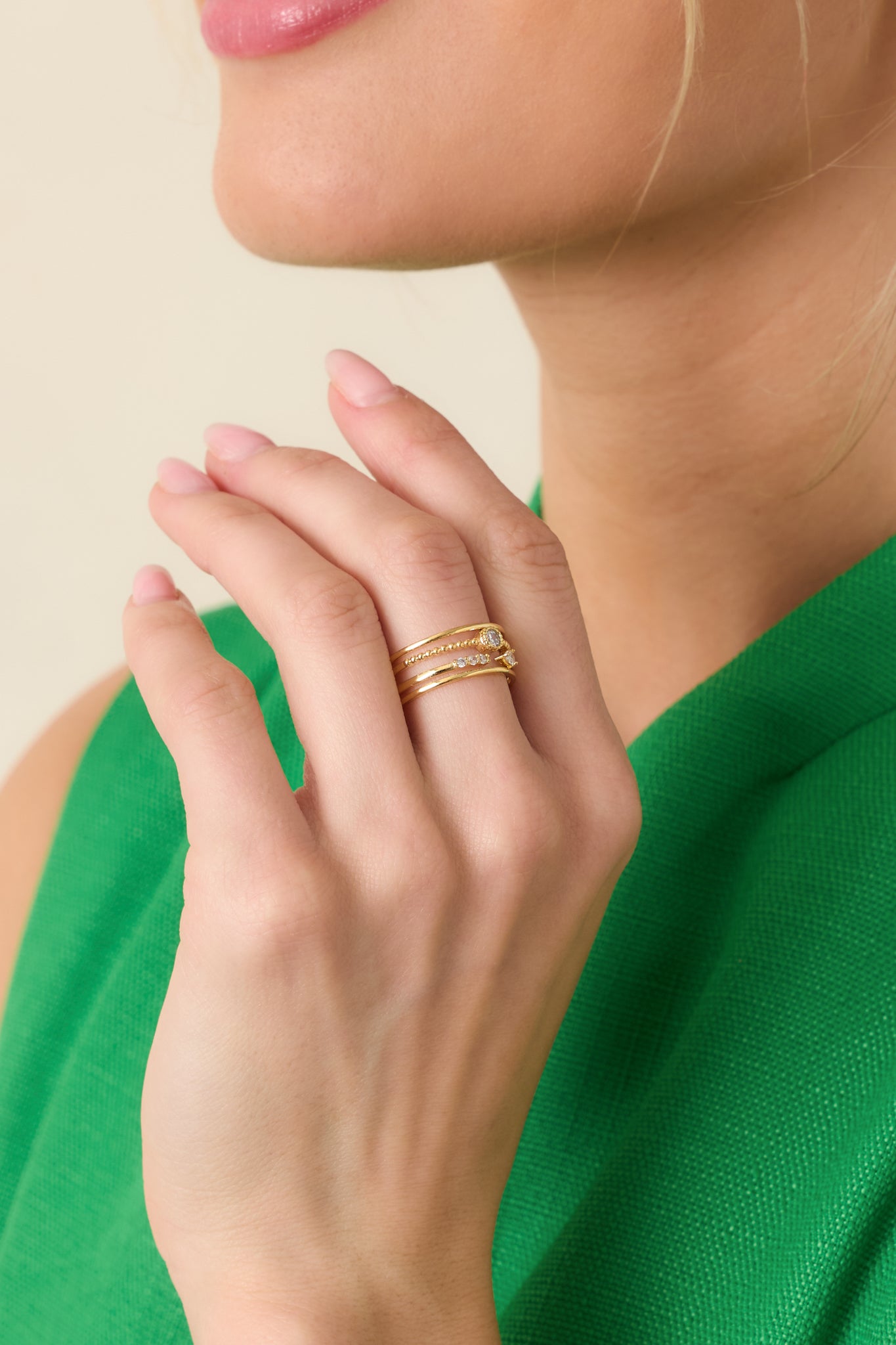 Cropped view of a gold layered ring with multiple slender bands and subtle rhinestone accents.