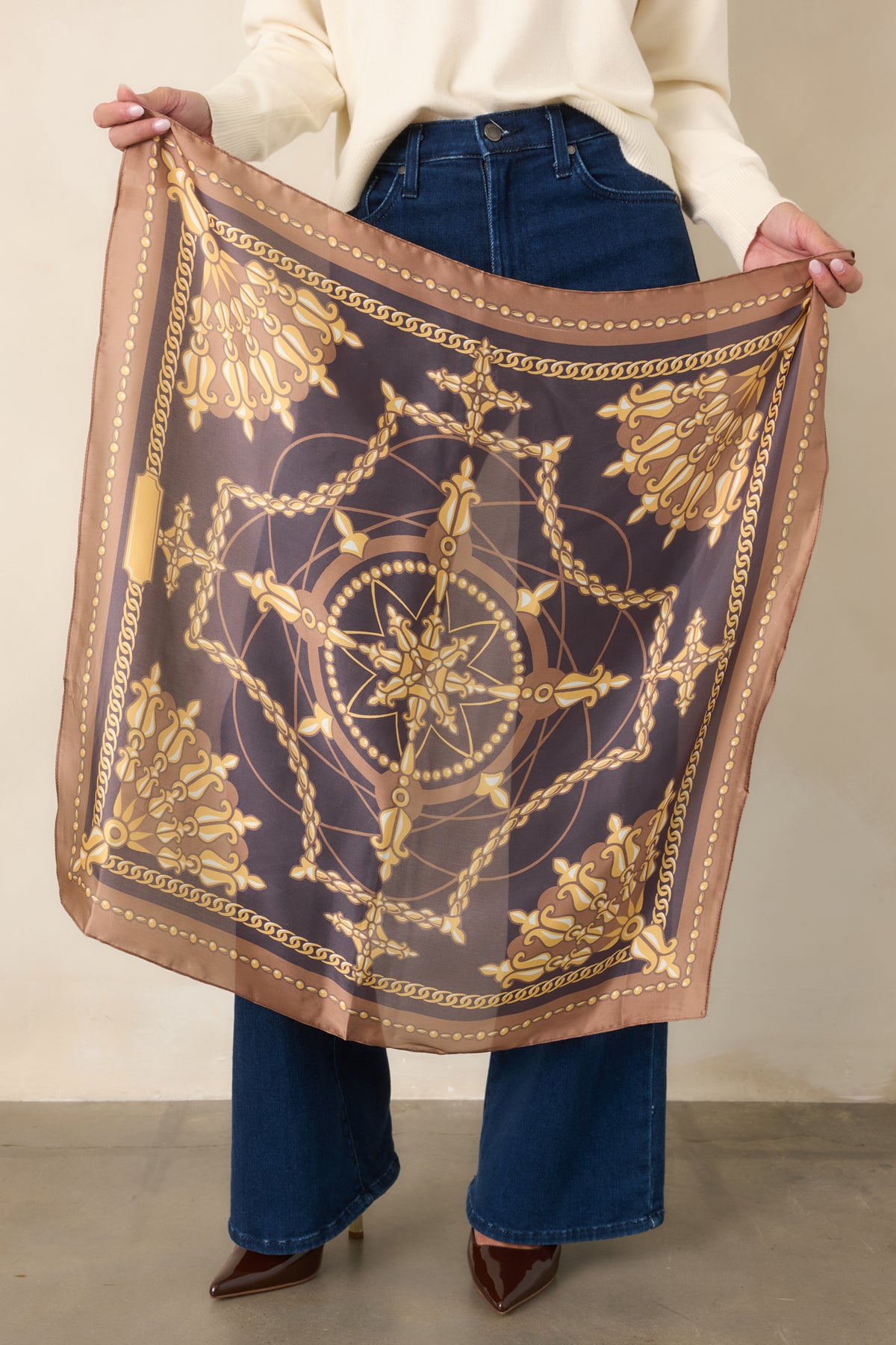 Scarf featuring decorative gold medallions and chain motifs against camel and charcoal grey tones.