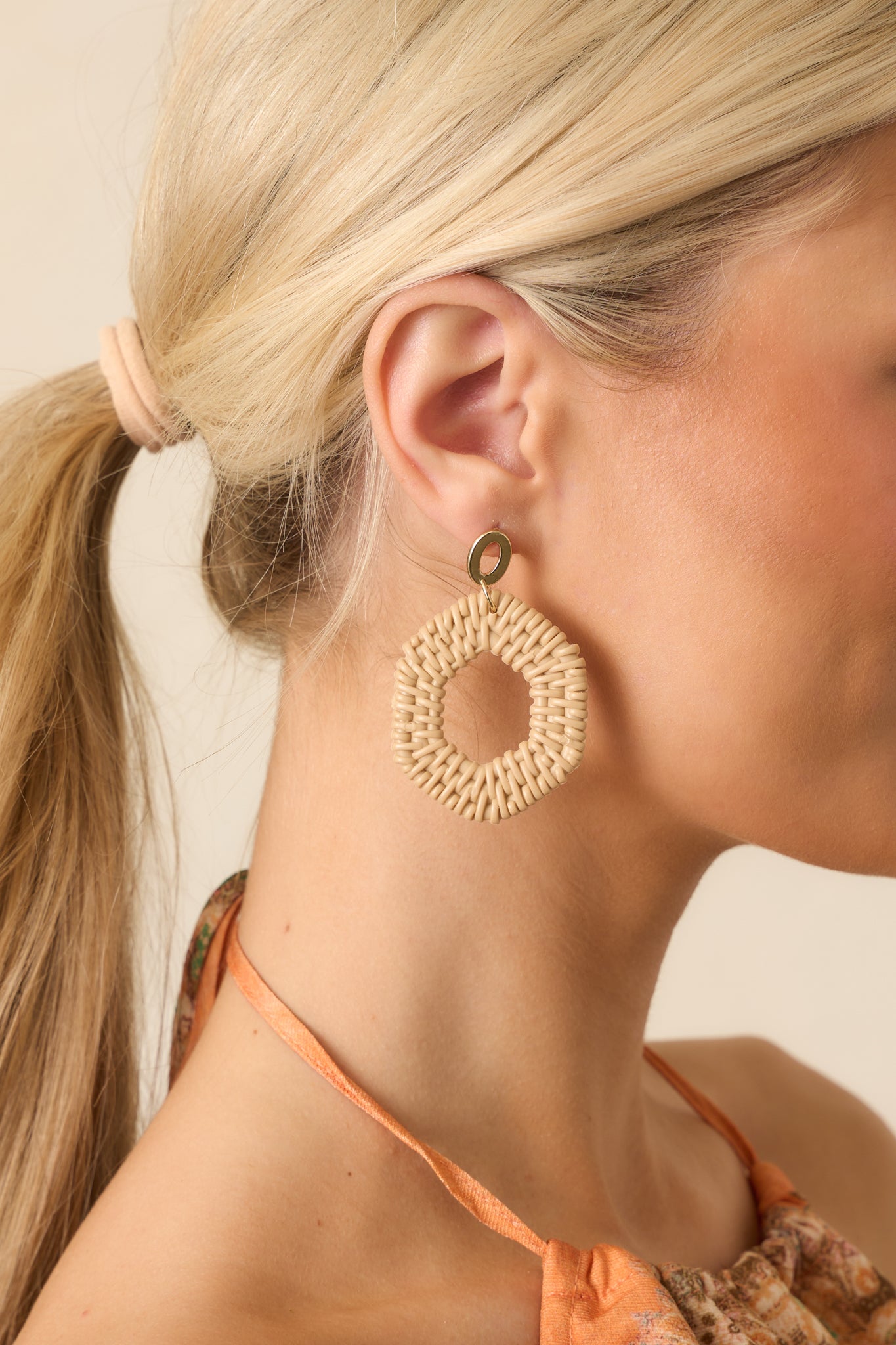 Frontal view of the earrings highlighting the hollow gold oval stud and the lightweight woven hexagon drop design.