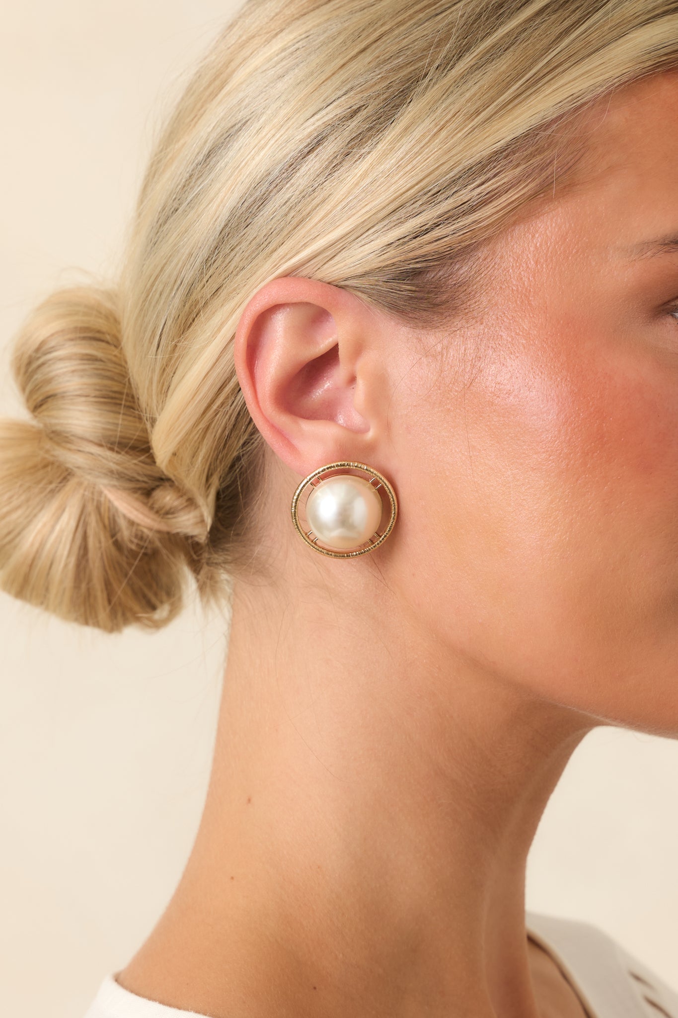 Gold-tone button earrings featuring luminous faux pearl centers framed by a textured halo for a timeless, vintage-inspired look.