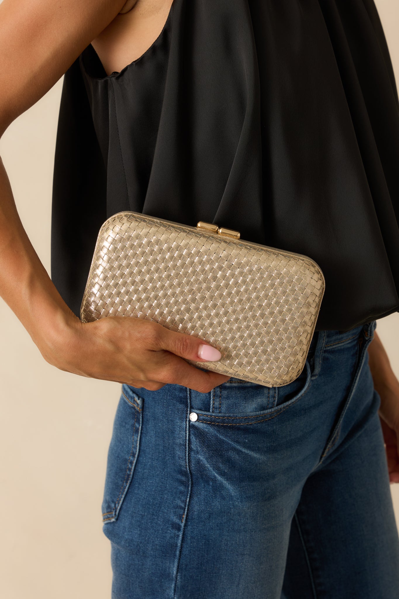 Gold structured rectangular clutch with a woven design and top clasp closure shown from the front.