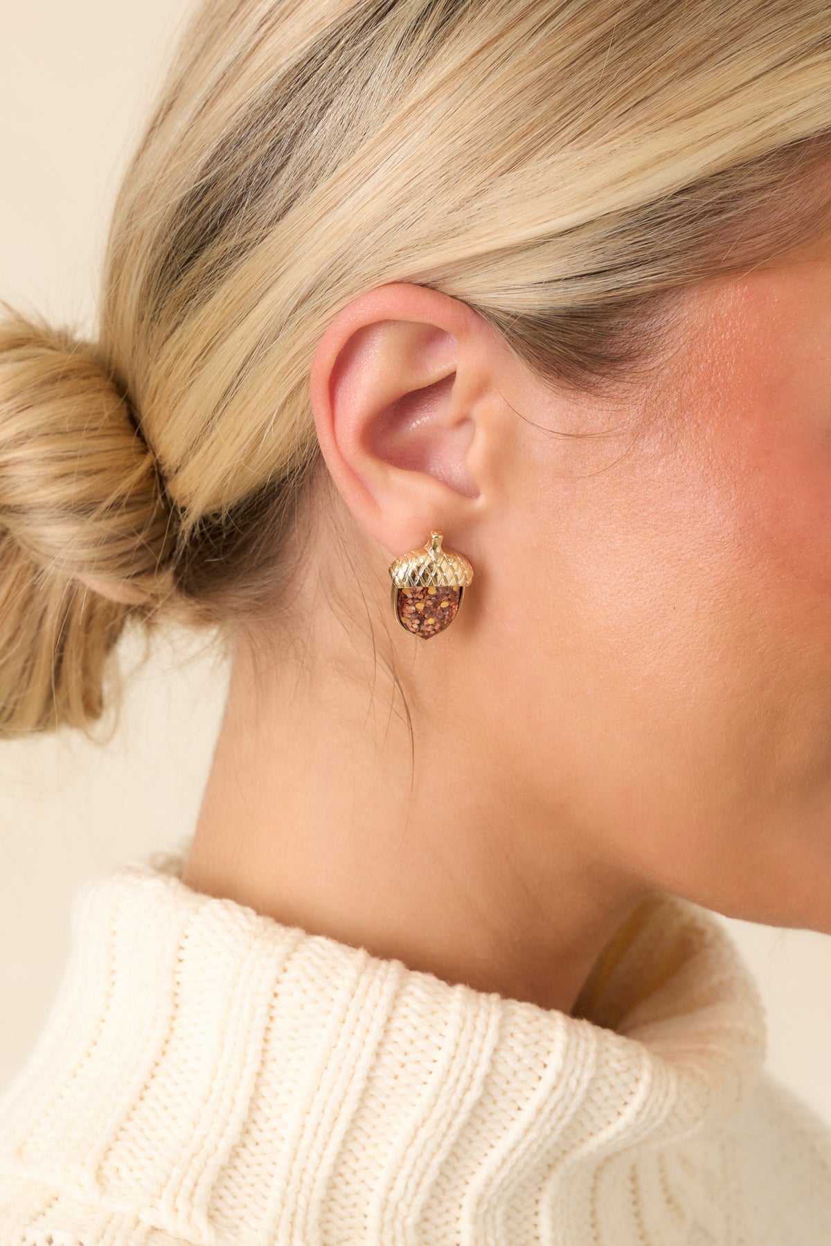 Gold-tone acorn stud earrings showcase glittering brown centers, crosshatched caps, and tiny decorative stems.