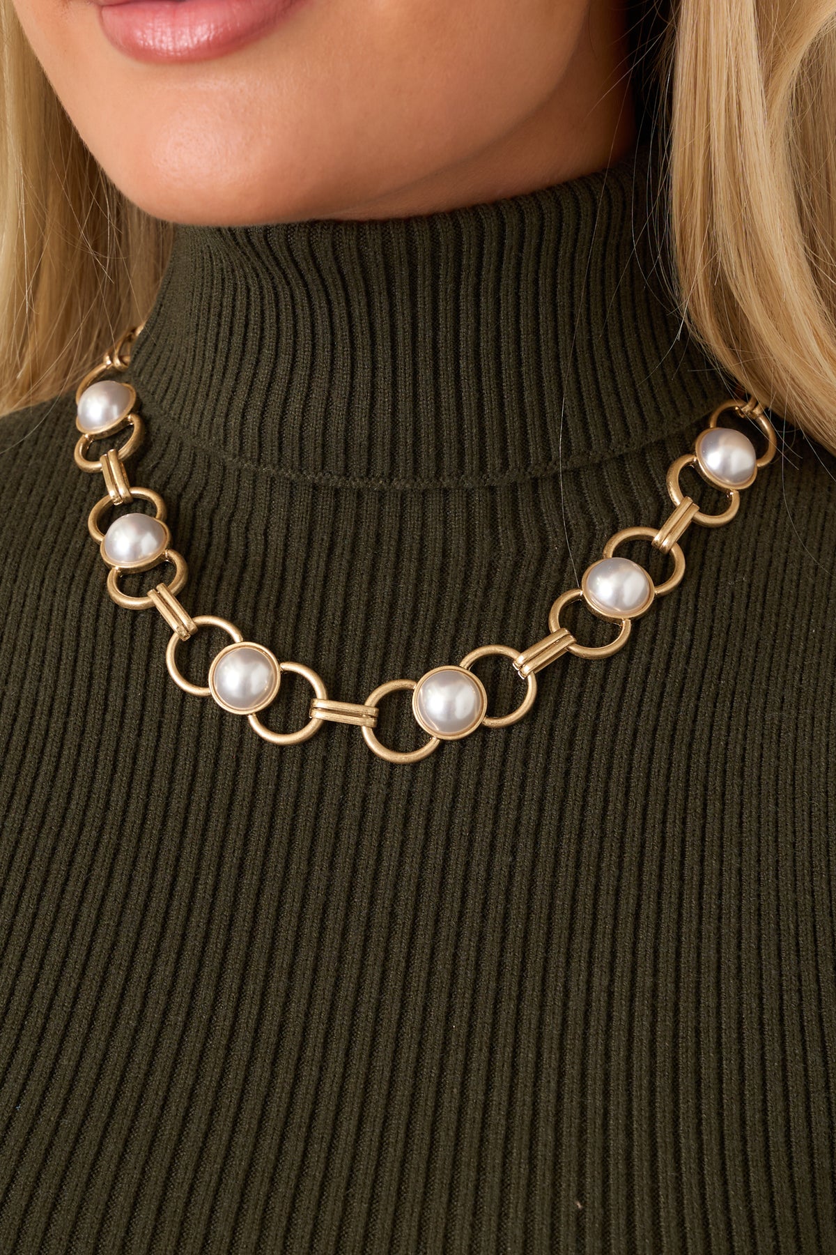 Gold-tone chain necklace with bold circular links, elongated bar connectors, and luminous pearl accents.