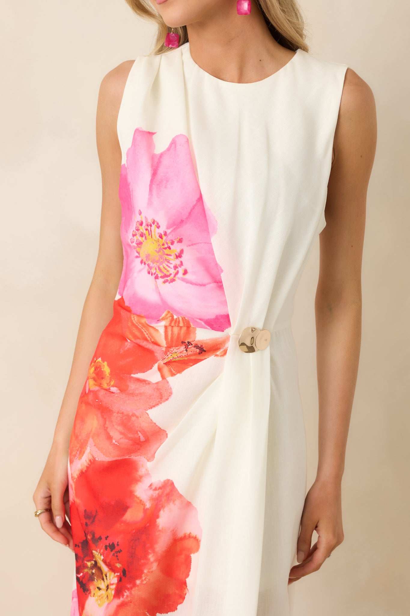 Gold-tone hardware accent and side pleating on ivory floral fabric.