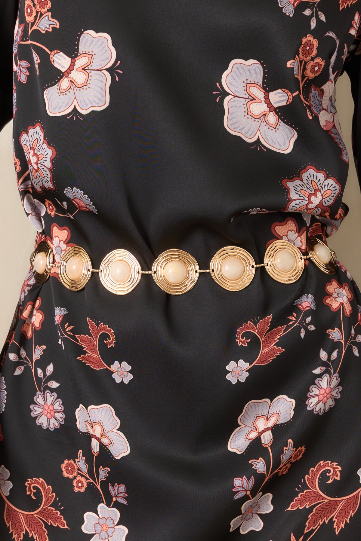 Linked gold-tone medallions feature rounded ivory centers with a marbled finish and sculpted rippled frames.